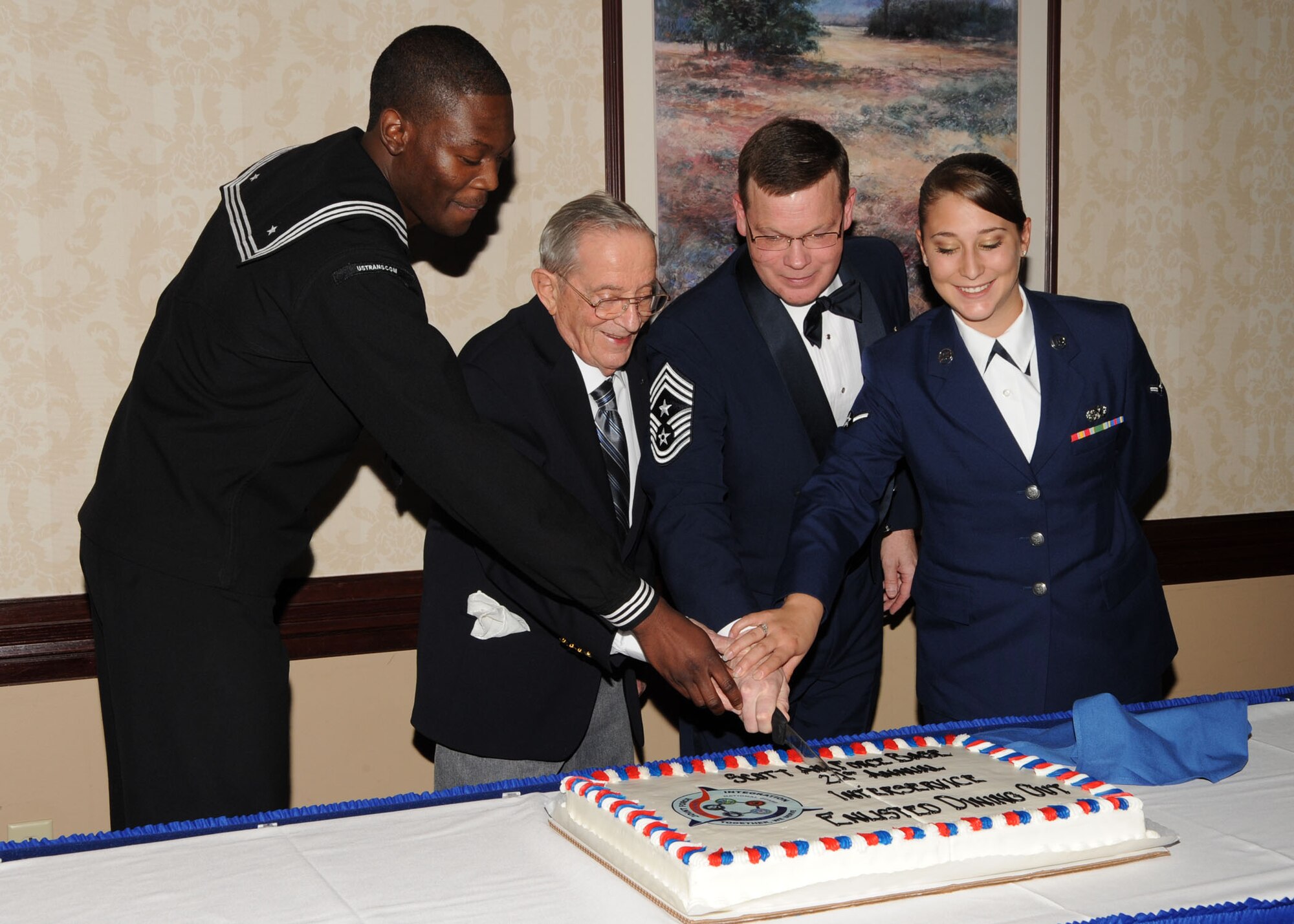 Scott AFB, Ill,; Members from the dining out are cutting the cake with Allen Chapin a World War 2 vetrian and former prisoner of war. Mr. Chapin was a 535th Bomb Squadron Sergeant with the Army Air Corps 381st Bomb Group. He was captured taken prisoner for 21 months before he was finally able to come home.  (U.S. Air Force Photo by Airman 1st Class Tristin English)