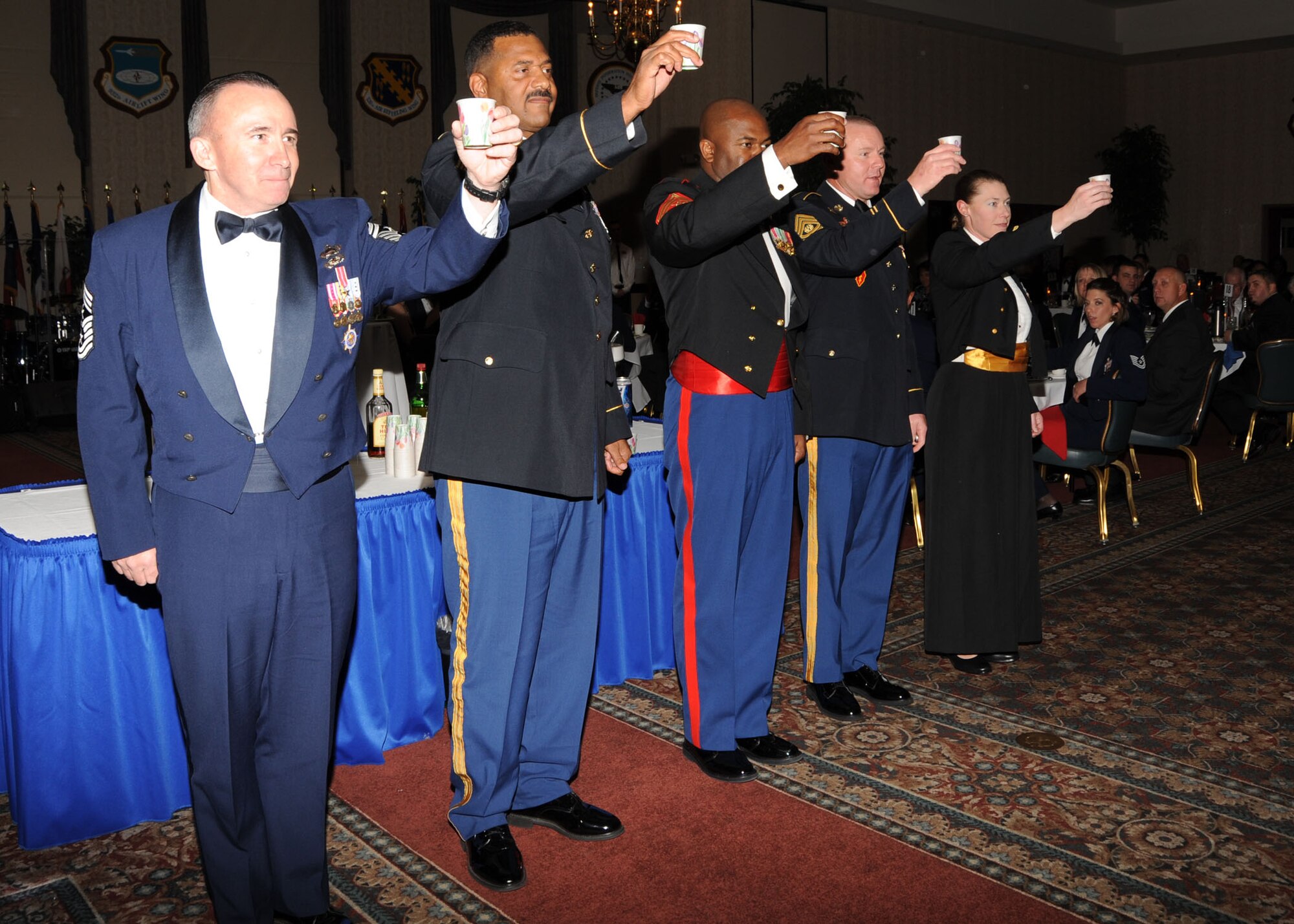 Scott AFB, Ill,; Five members from the head table raise their cups after filling them with a drink from the traditional grog bowls. The members toast “To the Mess” and then quickly drink the contents without moving the cup from their lips. If removed from their lips before it is empty they will have to get a new cup and do it again. (U.S. Air Force Photo by Airman 1st Class Tristin English)