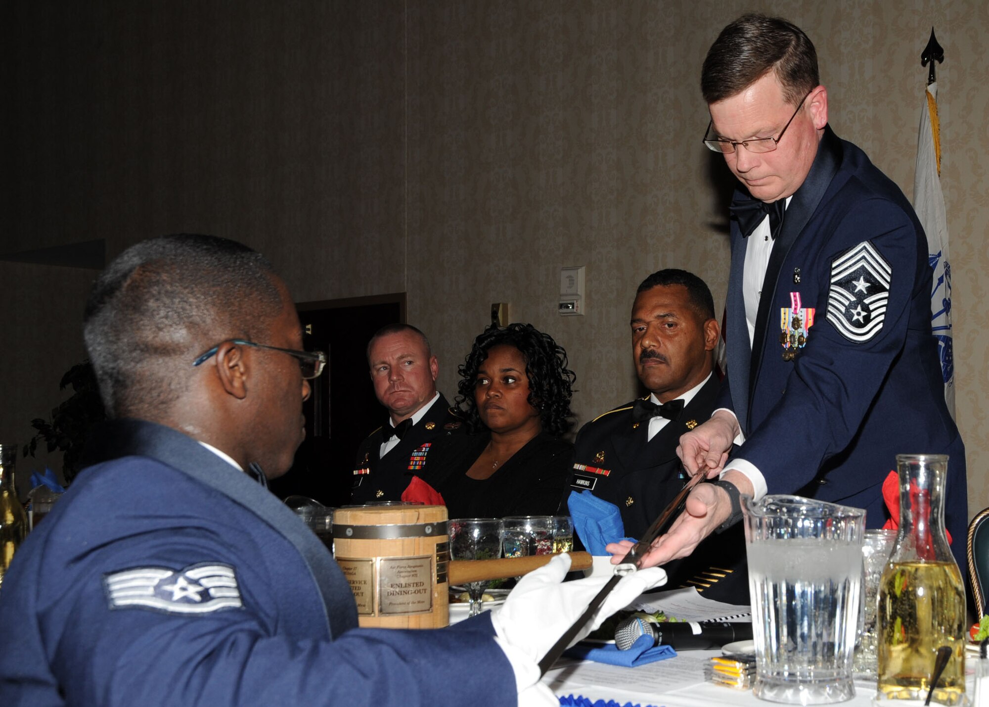 Scott AFB, Ill,; Staff Sgt. Joleen Outland presents Chief master Sgt. James Suttles with a sword during the opening ceremony. The sword is a symbol of laying down arms for the duration of the mess. (U.S. Air Force Photo by Airman 1st Class Tristin English)