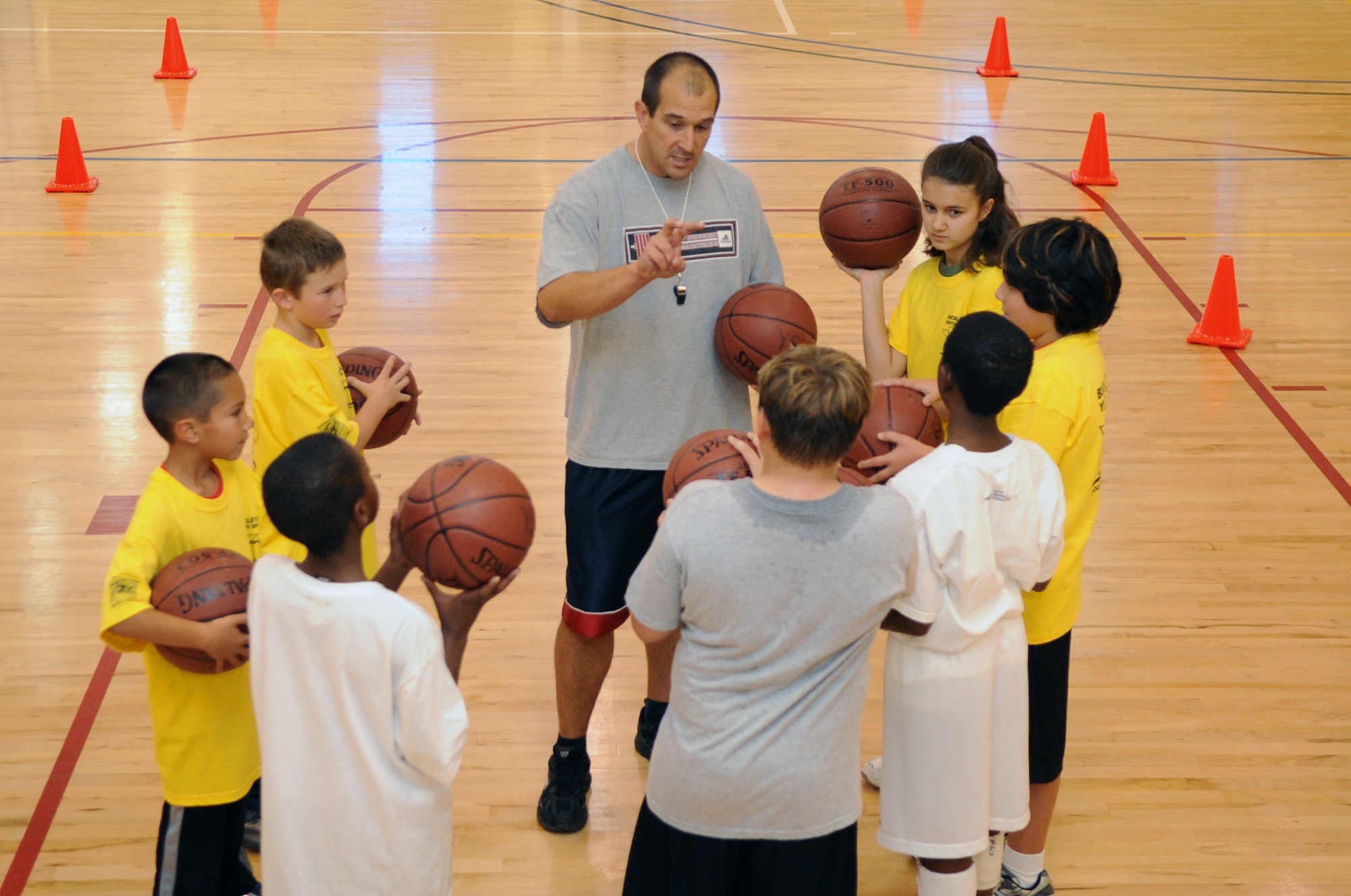 Tom Cox, 460th Force Support Squadron youth programs director, coaches Buckley youths on basketball fundamentals during a basketball clinic hosted by the 460th Force Support Squadron at the fitness center Oct. 17. (U.S. Air Force photo by Senior Airman John Easterling)