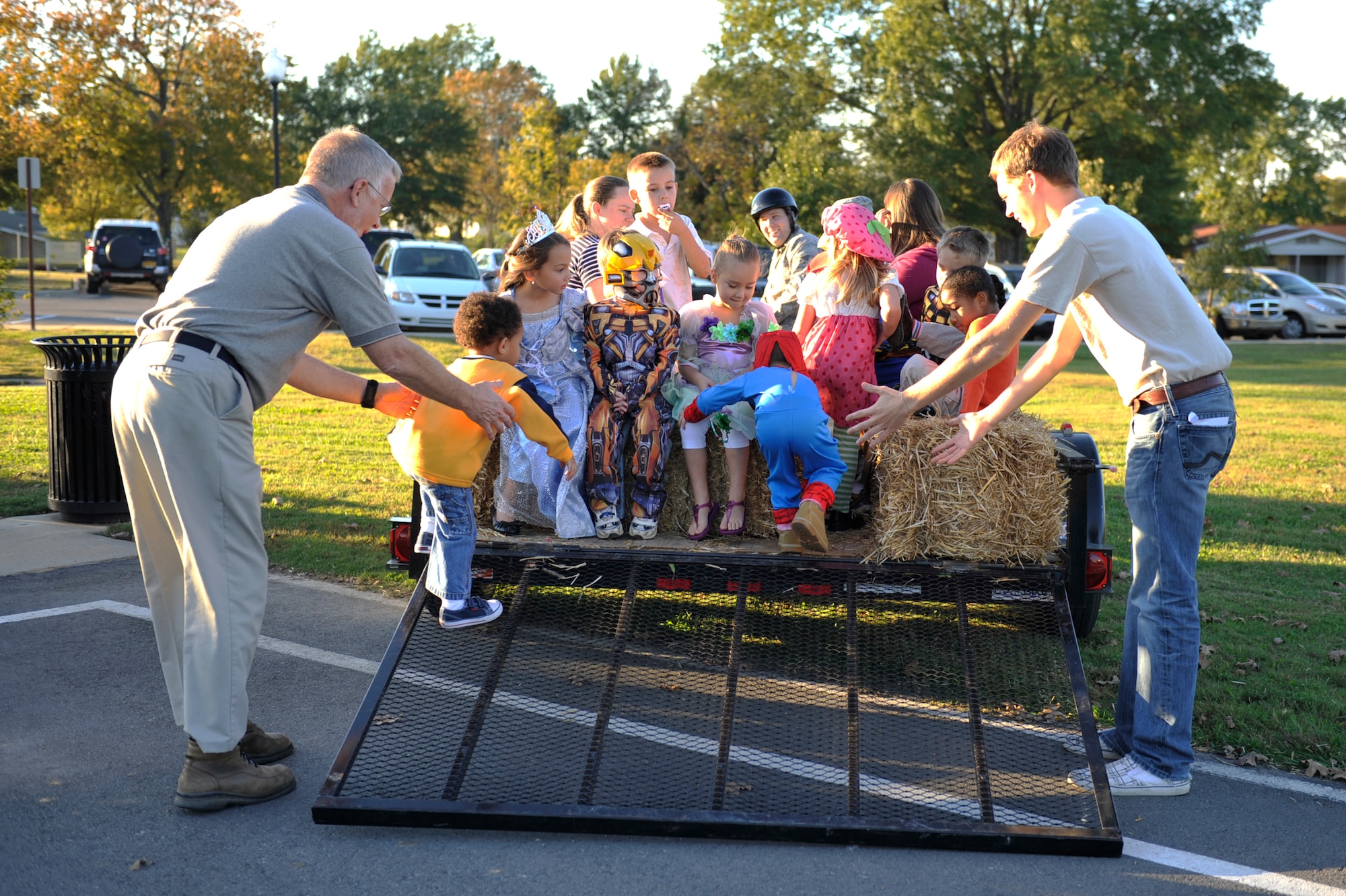 Jerry Rodgers, Pinnacle maintenance supervisor (left) and Thomas Ruhter, Pinnacle community organizer, guides children onto a hayride during the Harvest Festival held at the Welcome Center Oct. 20. There were 9 total activities during the Harvest Festival including hayrides, pumpin toss, sack race, and costume contests. (U.S. Air Force photo by Airman 1st Class Lausanne Pacheco)