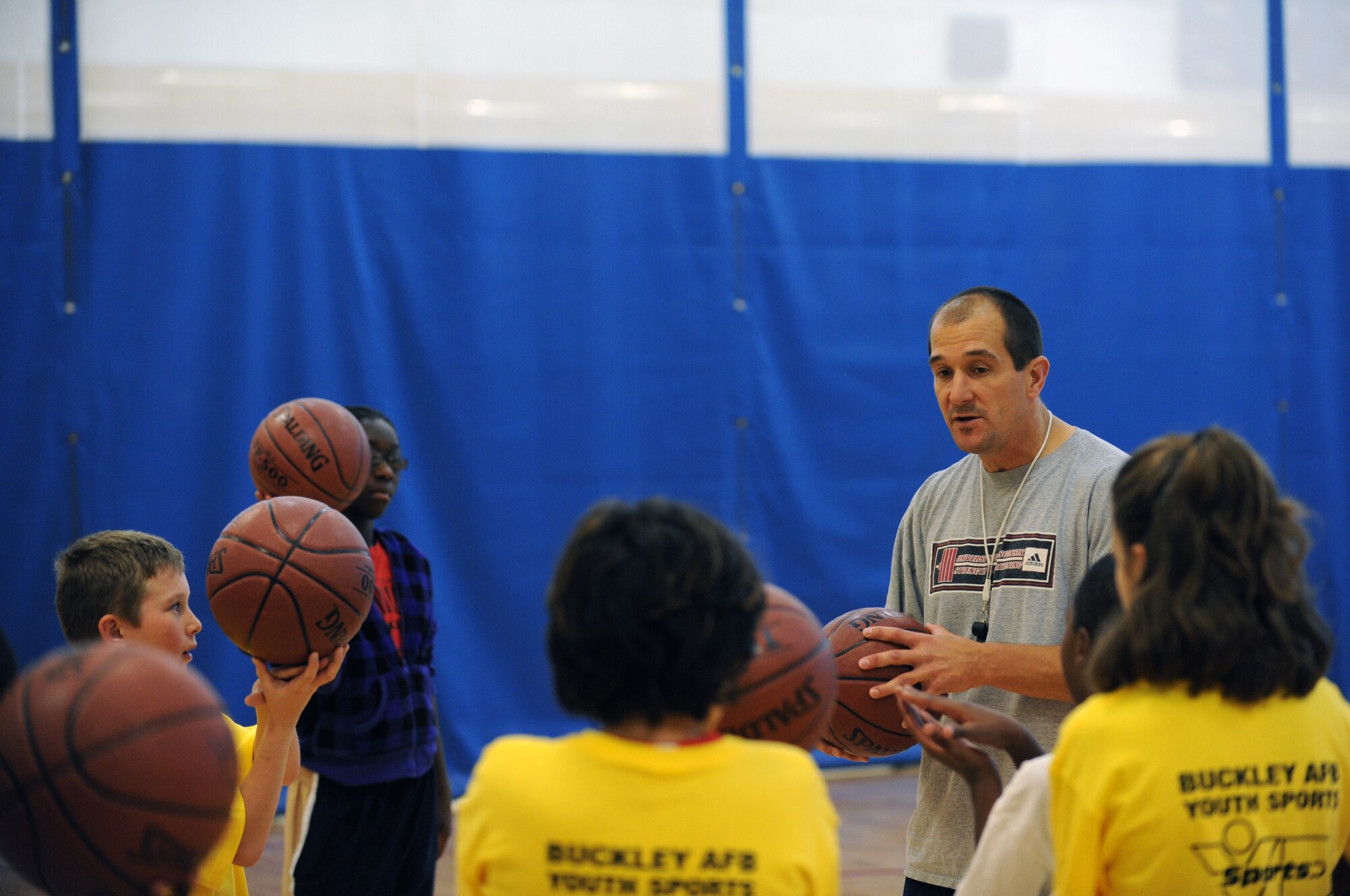 Tom Cox, 460th Force Support Squadron youth programs director, coaches Buckley youths on basketball fundamentals during a basketball clinic hosted by the 460th Force Support Squadron at the fitness center Oct. 17. (U.S. Air Force photo by Senior Airman John Easterling)