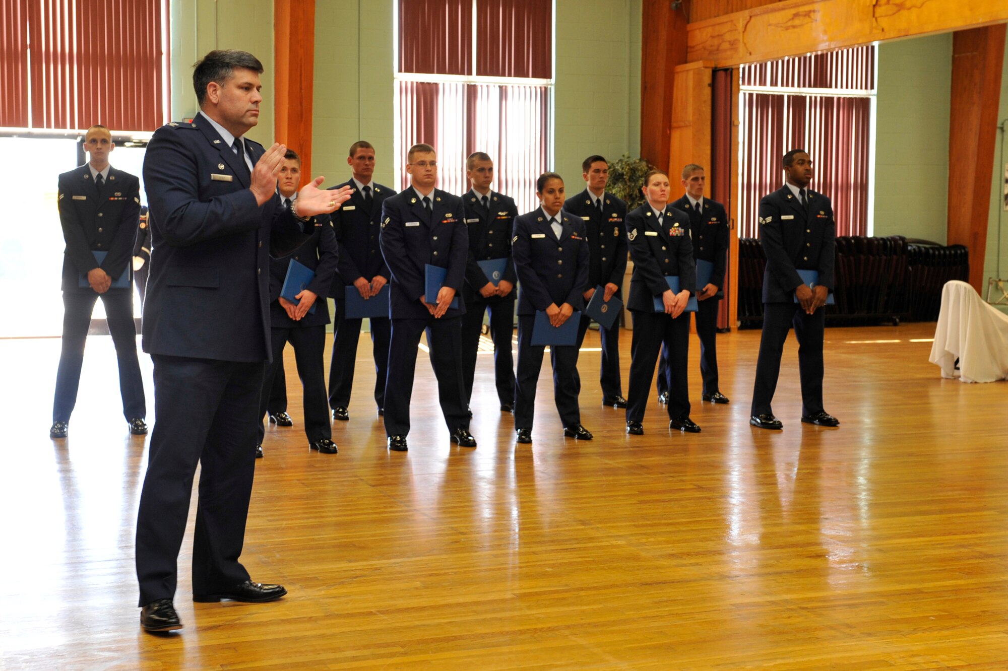 Col. Greg Otey, 19th Airlift Wing commander, applauds the newest  honor guard graduates during a ceremony on base Oct. 19. The Little Rock Air Force Base Honor Guard mission is to provide Military Honors for deserving veterans, retirees, active duty, Guard and Reserve members on base, in Arkansas and the surrounding area on behalf of the president of the United States, the department of the Air Force and a grateful nation. The honor guard performs more than 55 ceremonies on average per month. (U.S. Air Force photo by Airman 1st Class Lausanne Pacheco)