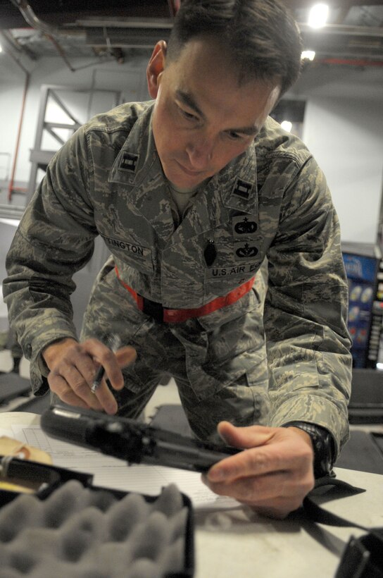 Captain Joseph Whittington, 89th Aerial Port Squadron director of operations, verifies his serial number on his issued 9mm pistol at the supply warehouse on Joint Base Andrews.  Captain Whittington and 19 other members of the 89th APS, departed for Alpena, Michigan Sunday to complete a 10 day training exercise.  (U.S. Air Force photo by Senior Airman Steven R. Doty)