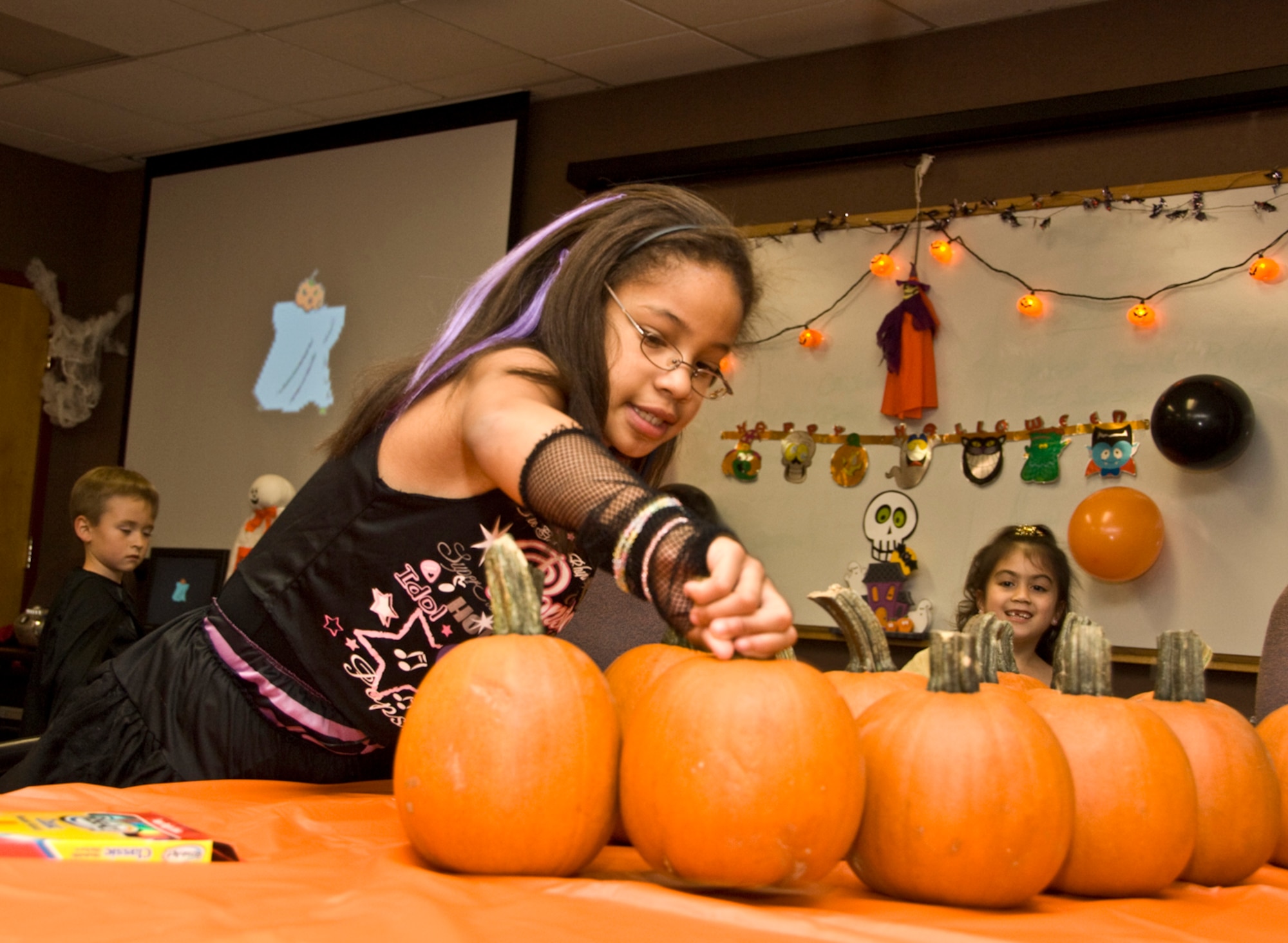 HANSCOM AIR FORCE BASE, Mass. – Gabriella Neufville selects a pumpkin to decorate during the Hearts Apart Halloween Party at the Airman and Family Readiness Center on Oct. 15. Families of deployed military personnel were treated to an evening of fun Halloween activities at the event. The Hearts Apart Program offers support and activities for families that have loved ones deployed. For more information on the program contact the A&FRC at (781) 377-4222. (U.S. Air Force photo by Mark Herlihy)