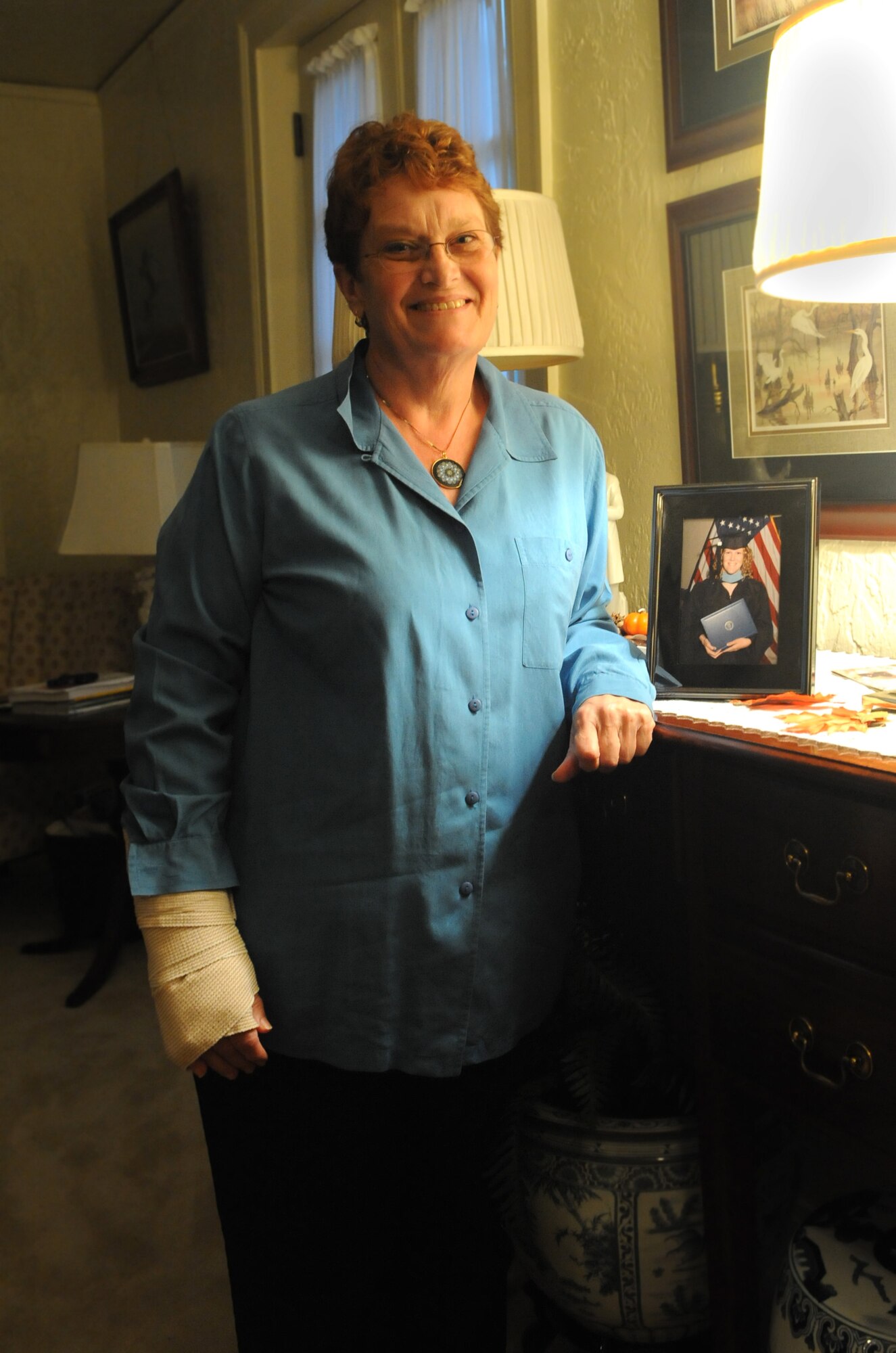 Mrs. Vaughn Grace, wife of Col. Thomas Grace, 2d Medical Group commander, poses next to a photo of her daughter. Mrs. Grace was diagnosed with breast cancer in August of 2001 and credits her recovery to the support of friends and family as well as a strong determination to beat the cancer. She advises early screening and constant communication with health care providers for anyone who suspects they may have breast cancer. (U.S. Air Force photo by Staff Sgt. Mike Andriacco) (RELEASED)