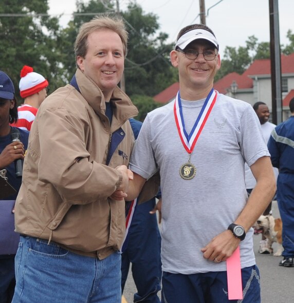 Tech. Sgt. James Custard, 2d Communications Squadron, shakes hands with Patrick Eicknell, Shreveport-Bossier Military Affairs Council, after the 5K run Oct. 16 during Celebrate Barksdale. He came in first place for his division with a time of 16 minutes, 34 seconds. The 5K was the first event of many during Celebrate Barksdale. (U.S. Air Force photo by Senior Airman Alexandra Longfellow) (RELEASED) 