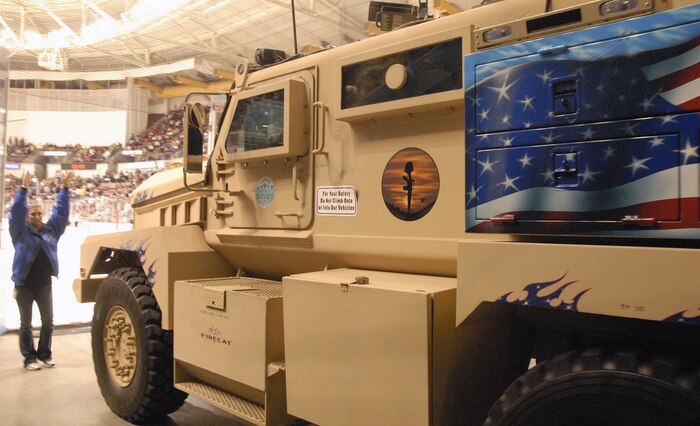 Lauri Lewellen directs the driver of a mine-resistant, ambush-protected vehicle as it enters the North Charleston Coliseum during the South Carolina Stingrays hockey team military appreciation night Oct. 16. The military vehicle was provided for display purposes in honor of the night's event and was assembled at a manufacturing facility in the local community. Ms. Lewellen is an international business development representative with Force Protection Industries. (U.S. Air Force photo/Staff Sgt. Daniel Bowles)