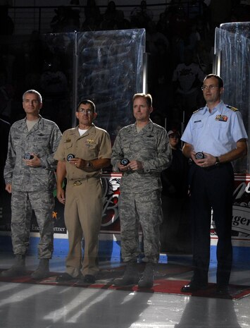 Col. John Wood, center right, joins, from left, Col. Steven Chapman, Navy Capt. Glenn Little Jr., and Coast Guard Cmdr. Scott Crawley for the puck drop at the start of the South Carolina Stingrays hockey team military appreciation night at the North Charleston Coliseum Oct. 16. The Stingrays donated more than 1,000 tickets for the game to military bases in and around Charleston, Beaufort and Columbia. Colonel Wood is the 437th Airlift Wing commander; Colonel Chapman is the 315th Airlift Wing commander; Captain Little is the Naval Weapons Station commanding officer and Commander Crawley is the Coast Guard Sector Charleston chief of enlisted personnel. (U.S. Air Force photo/Staff Sgt. Daniel Bowles)