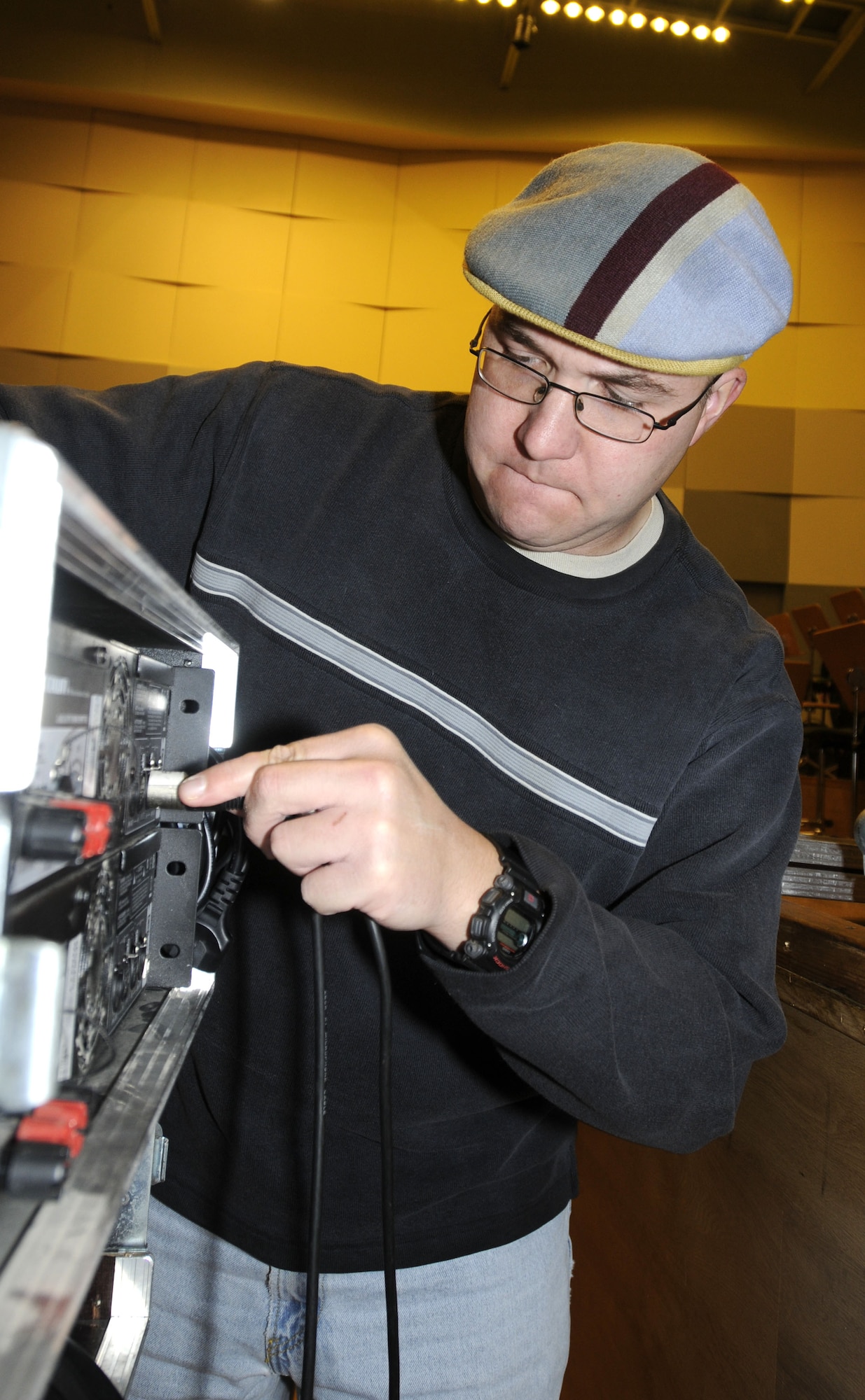 WROCLAW, Poland – Staff Sgt. Frank Gourley, trombone player, plugs a cable into audio equipment during setup prior to the USAFE Band’s concert here at the Downbeat Filharmonia im. Witolda Lutoslawskiego Oct. 20.  The band sets up and tears down the stage for each concert.  The USAFE Concert Band will play six concerts in Poland in support of Gen. Roger Brady’s, USAFE commander, international outreach program in partnership with the U.S. State Department.  (U.S. Air Force photo/Master Sgt. Kelley J. Stewart)