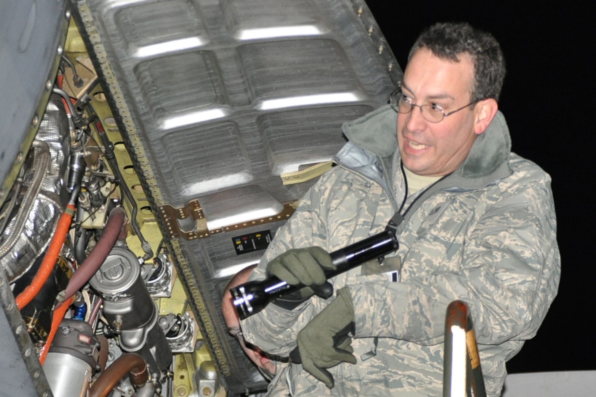 RAMSTEIN AIR BASE, Germany -- Air Force Reserve aircraft mechanics assigned to the 910th Airlift Wing use a flashlight to check the engine compartment as part of a basic post-flight inspection of a C-130 Hercules aircraft on the flightline here, Oct. 20, 2009. The aircraft and its crew, from Youngstown Air Reserve Station, Ohio, returned from an airlift mission to Tel Aviv, Israel. The YARS Airmen are participating in a deployment here in support of Operation Joint Enterprise, which provides airlift support throughout Europe and Africa. U.S. Air Force photo by Senior Airman Brenda Haines