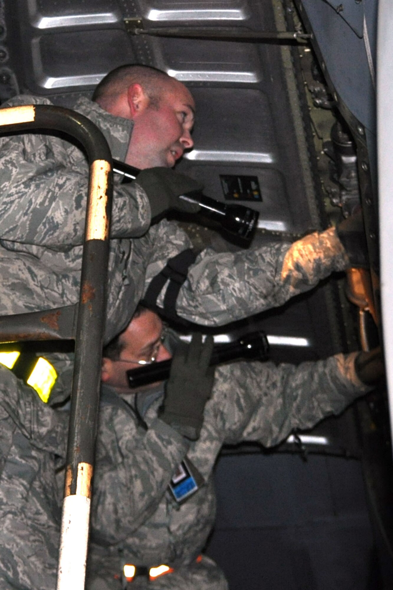 RAMSTEIN AIR BASE, Germany -- Air Force Reserve aircraft mechanics assigned to the 910th Airlift Wing use a flashlight to check the engine compartment as part of a basic post-flight inspection of a C-130 Hercules aircraft on the flightline here, Oct. 20, 2009. The aircraft and its crew, from Youngstown Air Reserve Station, Ohio, returned from an airlift mission to Tel Aviv, Israel. The YARS Airmen are participating in a deployment here in support of Operation Joint Enterprise, which provides airlift support throughout Europe and Africa. U.S. Air Force photo by Senior Airman Brenda Haines