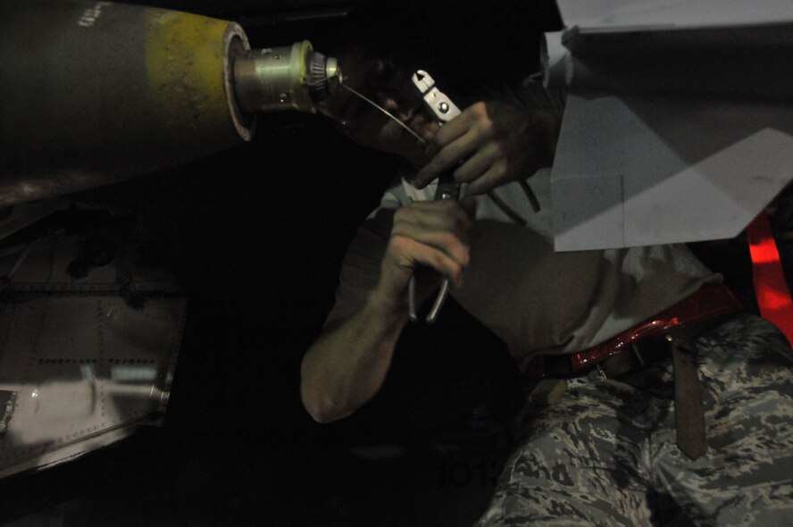 Senior Airman Derrick Pennington, a weapons load crew member, secures a Mark 82 onto an F-15 at Kunsan Air Base, Republic of Korea, Sept. 17. Airman Pennington is assigned to the 389th Expeditionary Fighter Squadron, deployed from Mountain Home Air Force Base, Idaho. Throughout the week, 389th EFS weapons loaders like Airman Pennington, along with other Airmen and pilots, trained with live munitions. (U.S. Air Force photo/Capt. Shannon Collins) 
