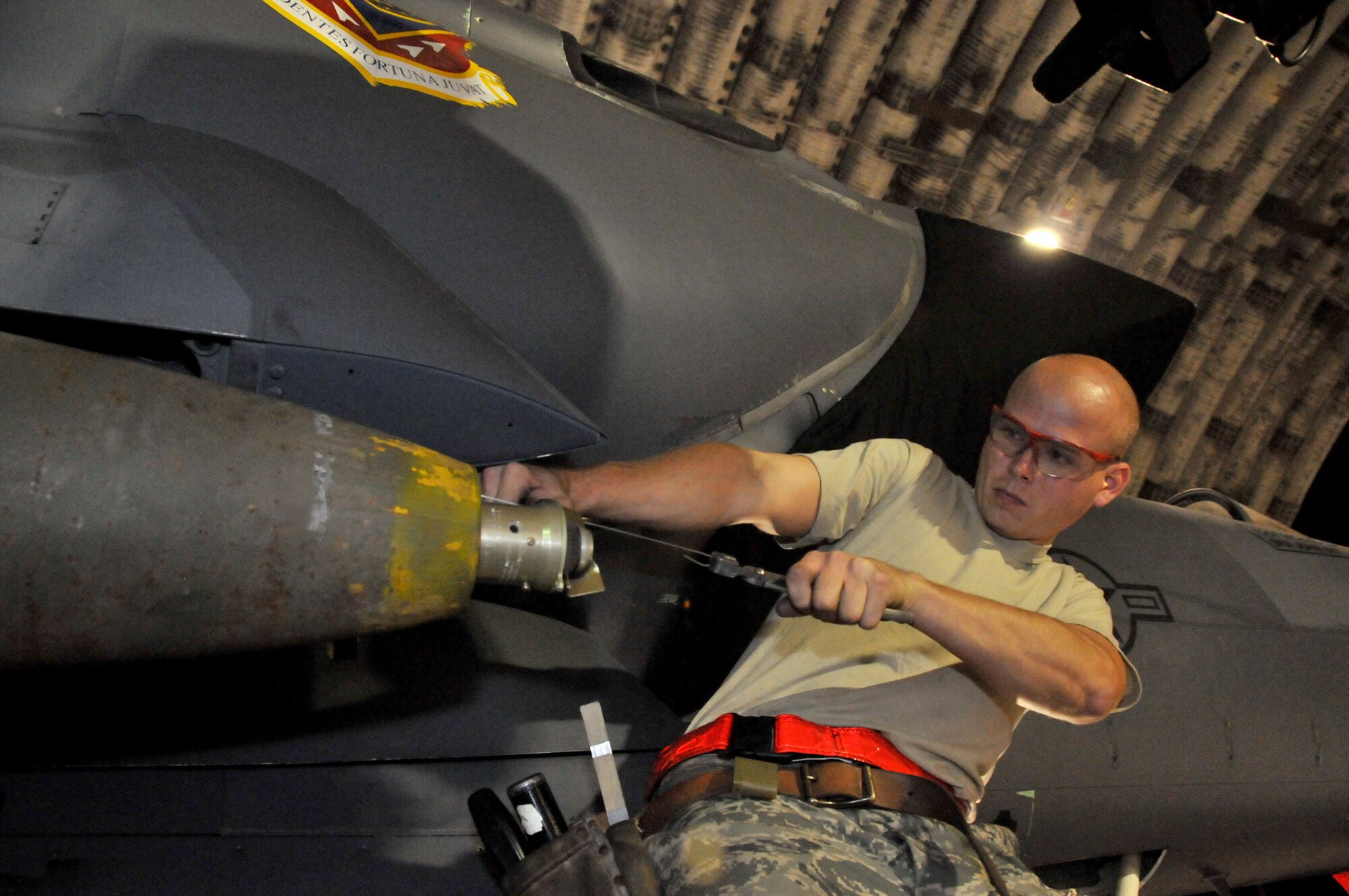 Senior Airman Derrick Pennington, weapons load crew member, secures a Mark 82 onto an F-15 at Kunsan Air Base, Republic of Korea, Sept. 17. Airman Pennington is assigned to the 389th Expeditionary Fighter Squadron, deployed from Mountain Home Air Force Base, Idaho. Throughout the week, 389th EFS weapons loaders like Airman Pennington, along with other Airmen and pilots, trained with live munitions. (U.S. Air Force photo/Capt. Shannon Collins) 