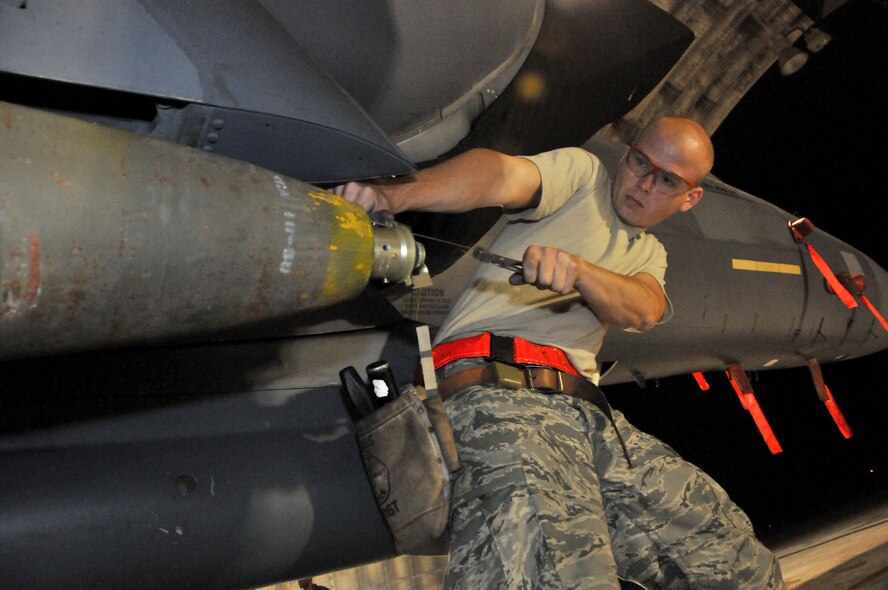 Senior Airman Derrick Pennington, weapons load crew member, secures a Mark 82 onto an F-15 at Kunsan Air Base, Republic of Korea, Sept. 17. Airman Pennington is assigned to the 389th Expeditionary Fighter Squadron, deployed from Mountain Home Air Force Base, Idaho. Throughout the week, 389th EFS weapons loaders like Airman Pennington, along with other Airmen and pilots, trained with live munitions. (U.S. Air Force photo/Capt. Shannon Collins) 