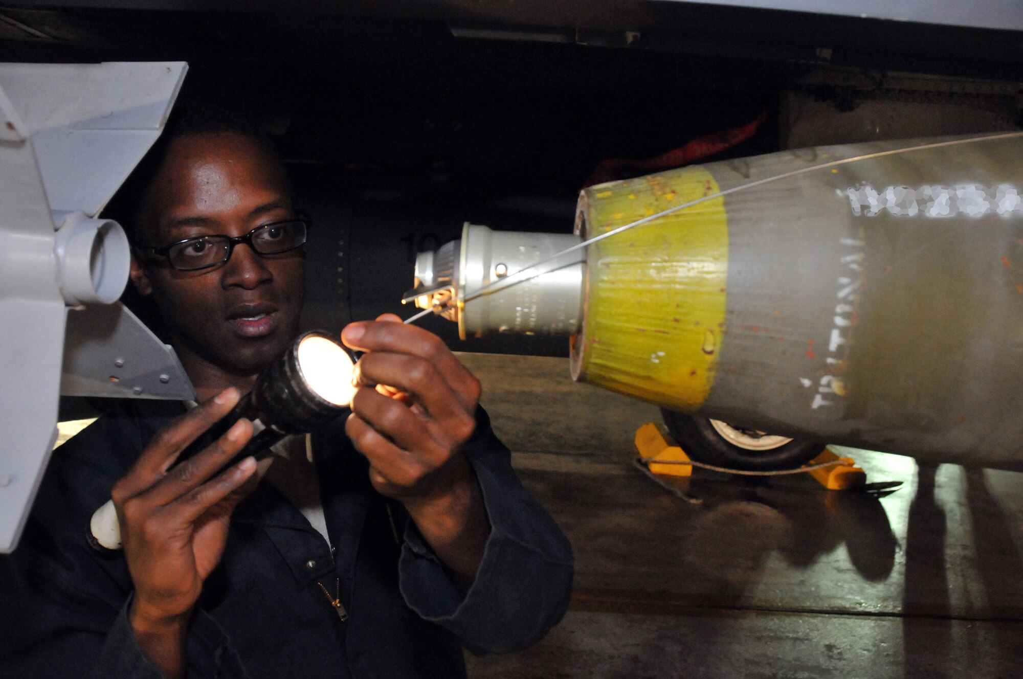 Staff Sgt. Dominique Battle, weapons load team chief, secures a Mark 82 onto an F-15 at Kunsan Air Base, Republic of Korea, Sept. 17. Sergeant Battle is assigned to the 389th Expeditionary Fighter Squadron, deployed from Mountain Home Air Force Base, Idaho. Throughout the week, 389th EFS weapons loaders like Airman Pennington, along with other Airmen and pilots, trained with live munitions. (U.S. Air Force photo/Capt. Shannon Collins) 
