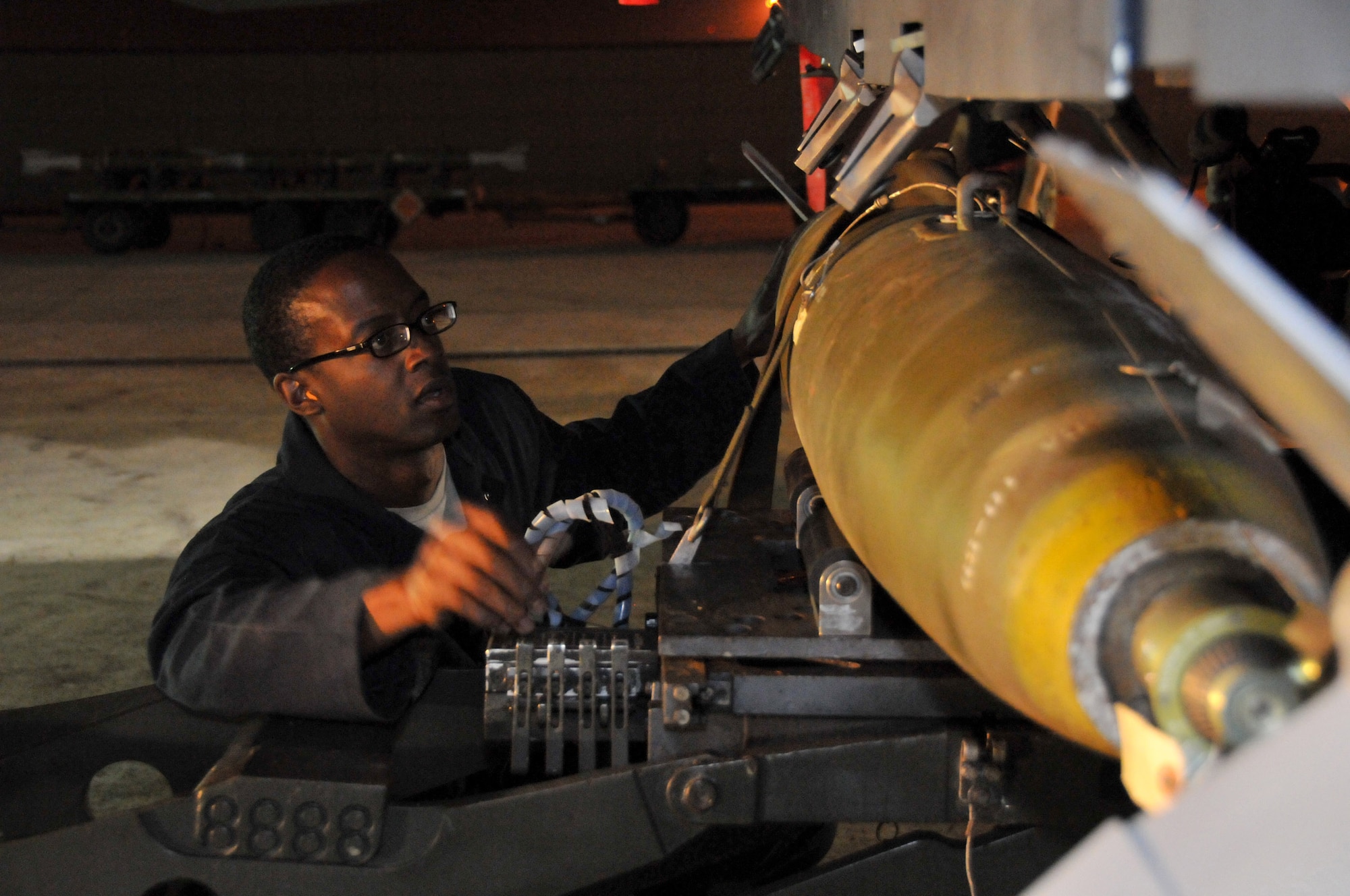 Staff Sgt. Dominique Battle, weapons load team chief, secures a Mark 82 onto an F-15 at Kunsan Air Base, Republic of Korea, Sept. 17. Sergeant Battle is assigned to the 389th Expeditionary Fighter Squadron, deployed from Mountain Home Air Force Base, Idaho. Throughout the week, 389th EFS weapons loaders like Airman Pennington, along with other Airmen and pilots, trained with live munitions. (U.S. Air Force photo/Capt. Shannon Collins) 