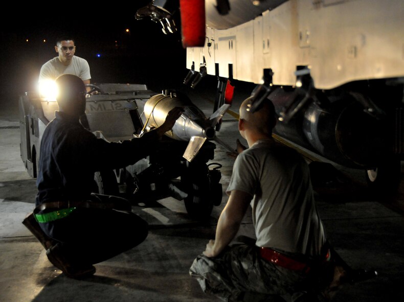 Airman 1st Class Ari Valdez, weapons load crew member, steers a jammer with a "live" Mark 82 as Staff Sgt. Dominique Battle, weapons load team chief, keeps it steady and Senior Airman Pennington, weapons load crew member, prepares to load it onto an F-15 at Kunsan Air Base, Republic of Korea, Sept. 17. Sergeant Battle and Airmen Pennington and Valdez are assigned to the 389th Expeditionary Fighter Squadron, deployed from Mountain Home Air Force Base, Idaho. Throughout the week, 389th EFS weapons loaders, along with other Airmen and pilots, trained with live munitions. (U.S. Air Force photo/Capt. Shannon Collins) 