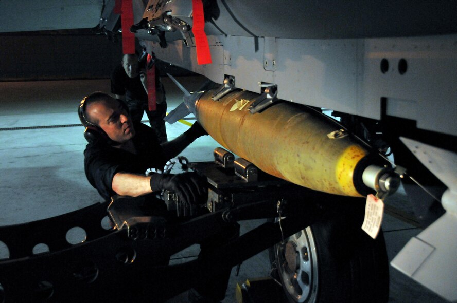 Staff Sgt. Matthew Modgling, weapons load team chief, secures a Mark 82 onto an F-15 as Tech. Sgt. Jeremy Stradtmann, weapons expediter, looks on at Kunsan Air Base, Republic of Korea, Sept. 17. Sergeants Modgling and Stradtmann are assigned to the 389th Expeditionary Fighter Squadron, deployed from Mountain Home Air Force Base, Idaho. Throughout the week, 389th EFS weapons loaders, along with other Airmen and pilots, trained with live munitions. (U.S. Air Force photo/Capt. Shannon Collins) 