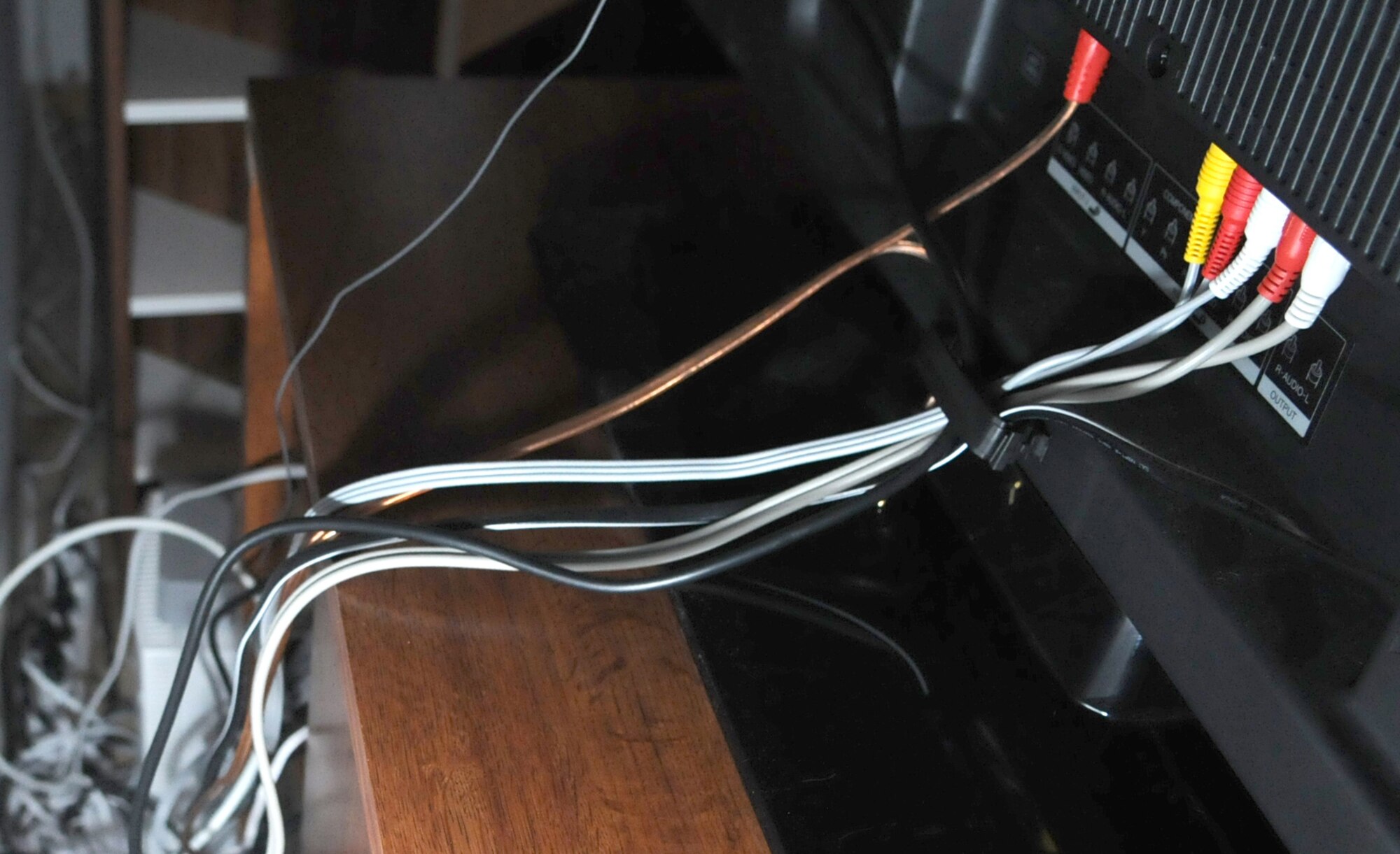 Behind Tech. Sgt. Sean White's 52 inch television lives a mass of speaker and power cords.  A typical entertainment system consists of a television, Stereo, an AFN receiver and often times a game console.  If your household electronics require a transformer unplug the transformer from the wall when not in use.  Transformers consume electricity whenever they are plugged in regardless of whether the 120V outlet is being used or not.  October is energy conservation month which provides us the opportunity to increase awareness of the energy challenges that confront our planet.  If we all make an effort to develop our own personal conservation habits, together we can make a difference.  (U.S. Air Force photo by: Tech. Sgt. Sean M. White)
