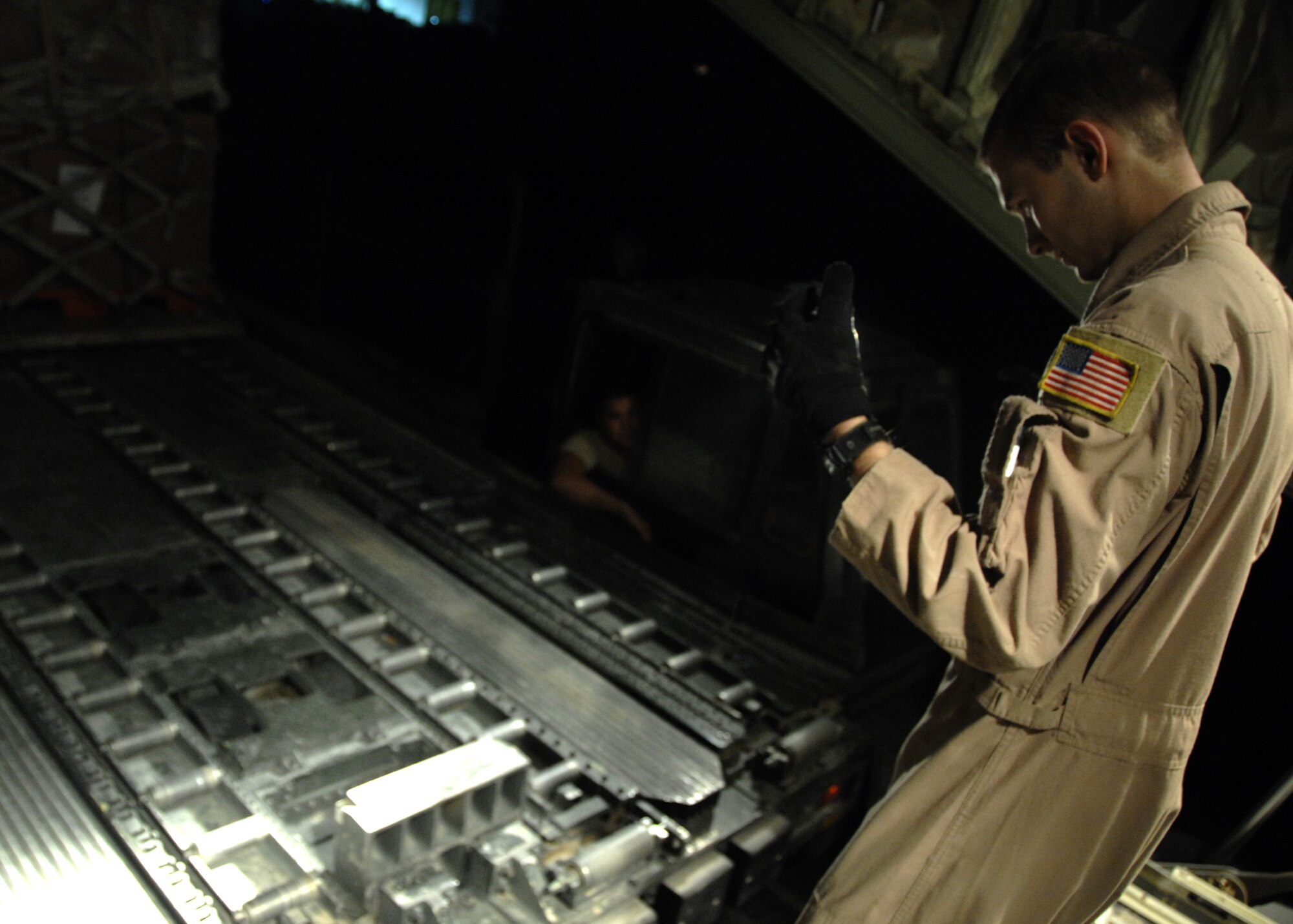 Senior Airman Scott McGuire directs a 60k Tunner to the back of a C-130J to upload cargo to be transported down range here, Oct. 17, 2009. This particular cargo shipment is destined for Al Udeid delivering various supplies and goods to the base. Airman McGuire is a C-130 loadmaster for the 772nd Expeditionary Airlift Squadron from Little Rock Air Force Base, Ark. (U.S. Air Force photo/Senior Airman Timothy Taylor)