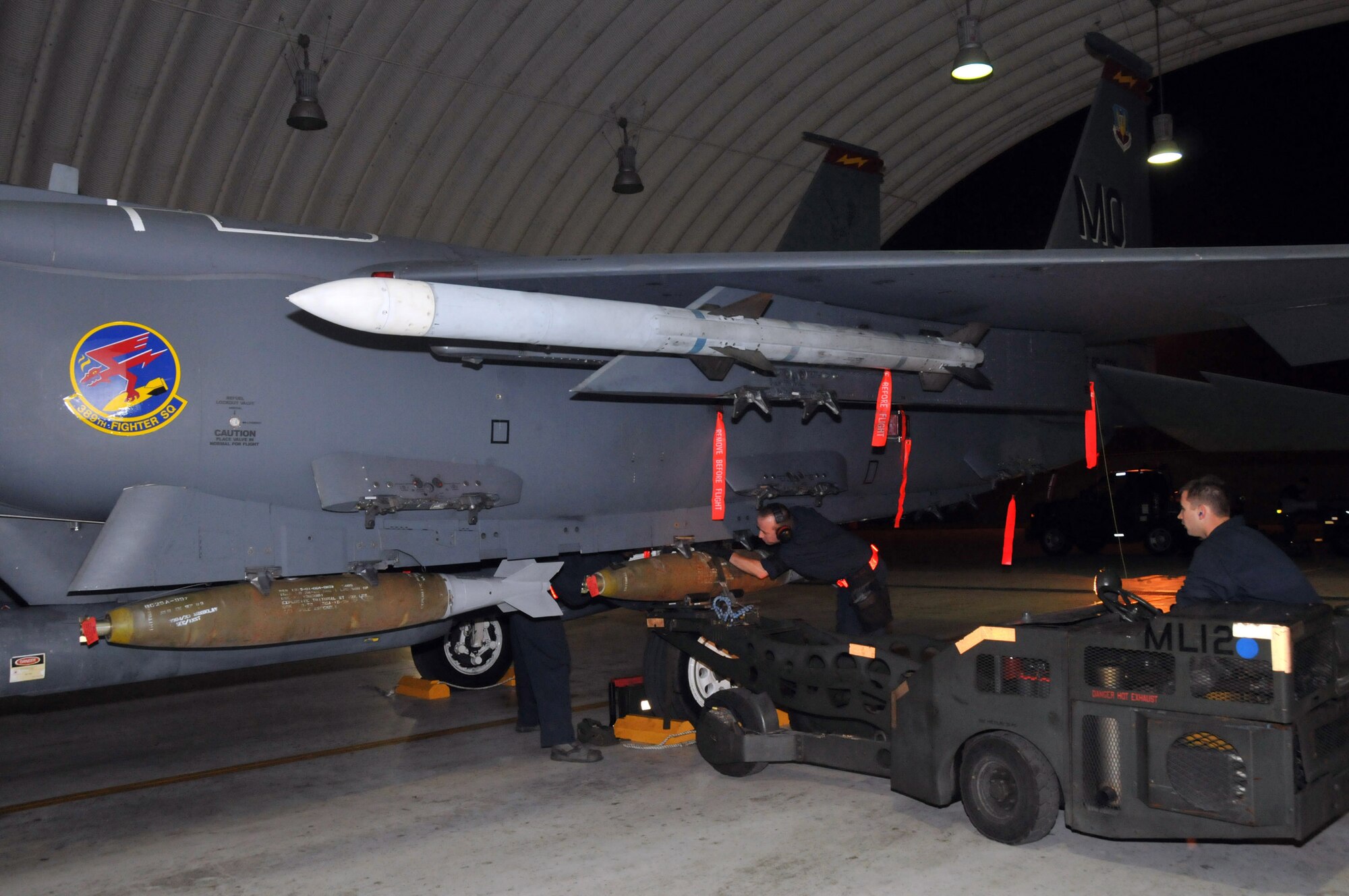 Staff Sgt. Matthew Modgling, weapons load team chief, secures a Mark 82 after Senior Airman Nathan Harman, weapons load crew member, steers a "jammer" toward an F-15 at Kunsan Air Base, Republic of Korea, Sept. 17. Sergeant Modgling and Airman Harman are assigned to the 389th Expeditionary Fighter Squadron, deployed from Mountain Home Air Force Base, Idaho. Throughout the week, 389th EFS weapons loaders, along with other Airmen and pilots, trained with live munitions. (U.S. Air Force photo/Capt. Shannon Collins) 