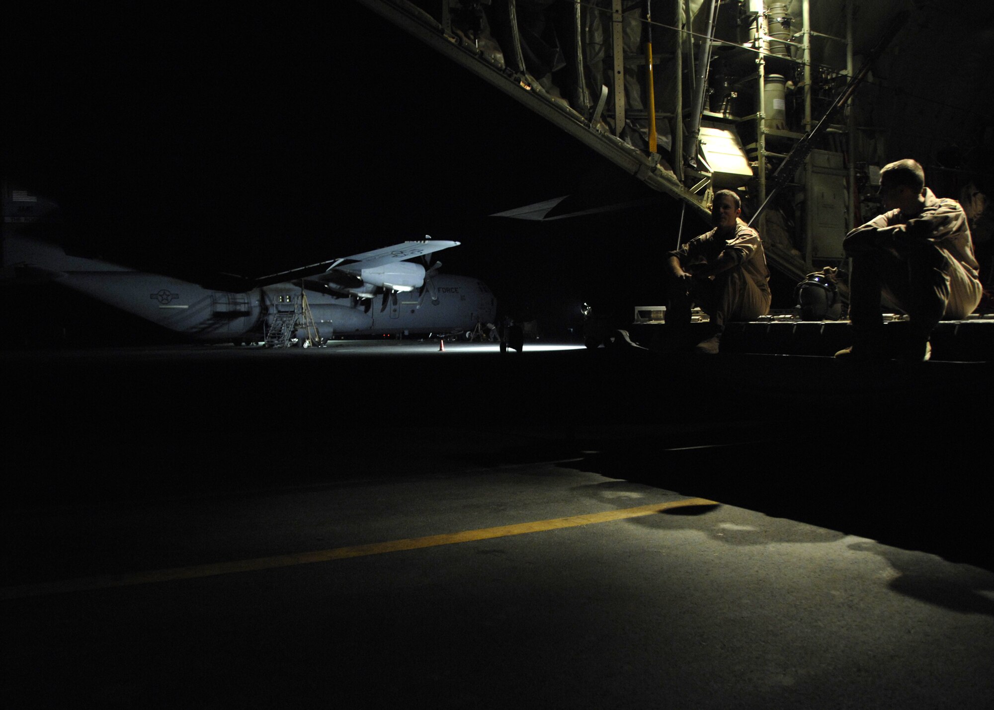 Senior Airman Duan Jensen and Scott McGuire sit in the cargo bay of a C-130J waiting for the aircrafts cargo here, Oct. 17, 2009. Airman Jensen and McGuire are C-130 loadmasters for the 772nd Expeditionary Airlift Squadron from Little Rock Air Force Base, Ark. (U.S. Air Force photo/Senior Airman Timothy Taylor)