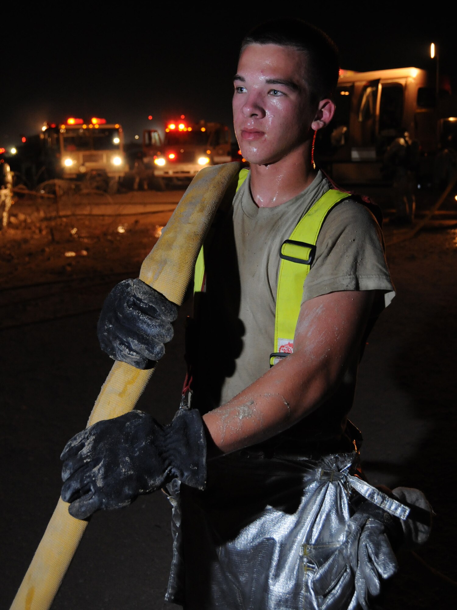 Airman 1st Class Matthew Torries, 379th Expeditionary Civil Engineer Squadron firefighter, drains excess water from a fire hose after helping extinguish a major fire on base, Oct. 20, 2009. Airman Torries, deployed from Travis Air Force Base, Calif., was the first responder on scene. (U.S. Air Force Photo/Tech. Sgt. Jason W. Edwards)