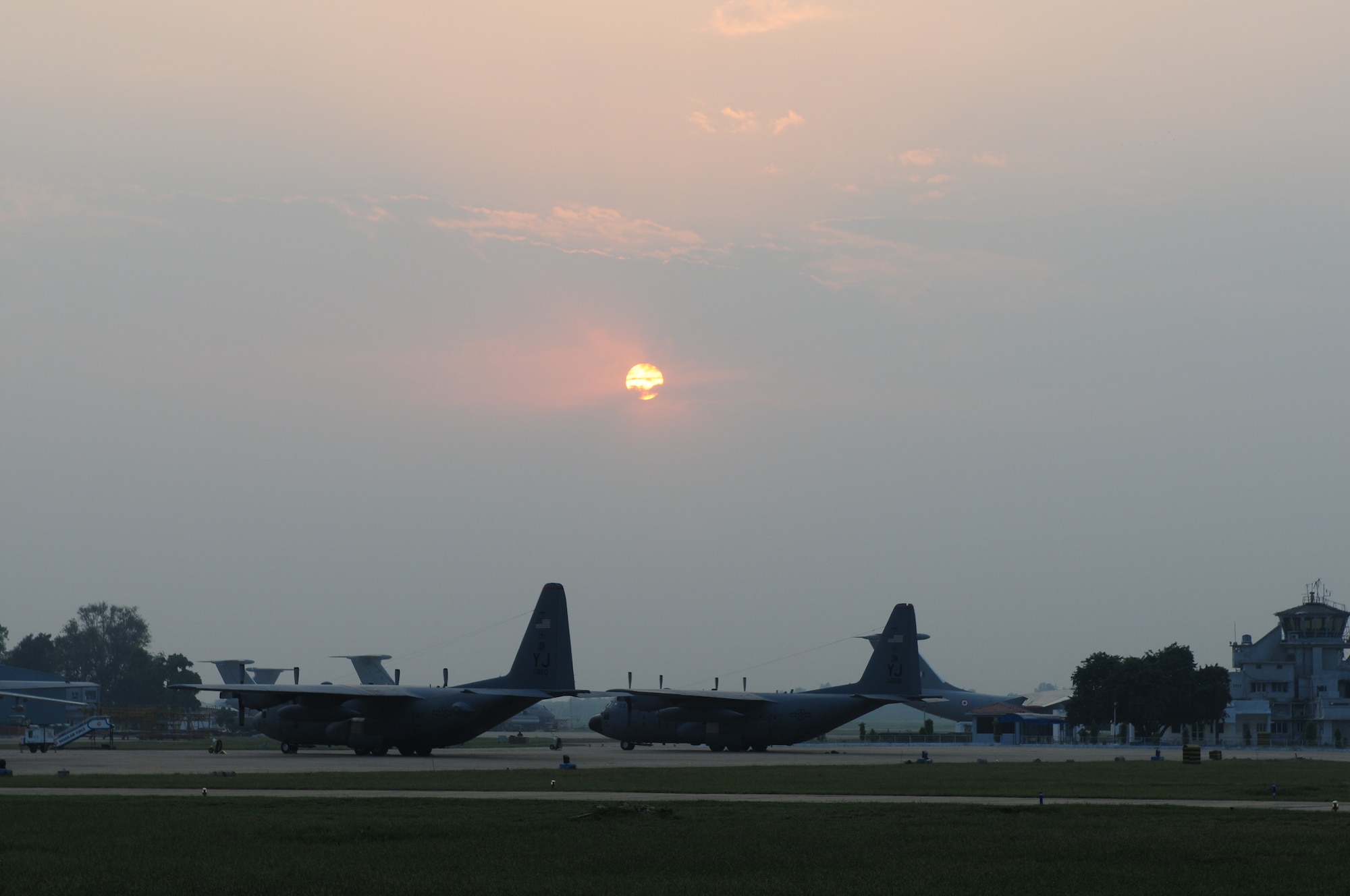 After a long days work, two U.S. Air Force C-130 Hercules from the 36th Airlift Squadron, from Yokota Air Base, Japan, rest at the days end under a Indian sunset at Air Force Station Agra. The aircraft along with 150 U.S. Air Force and Army personnel are deployed here as part of exercise Cope India, a humanitarian assistance disaster relief exercise Oct. 19-24. (U.S. Air Force photo/Capt. Genieve David)