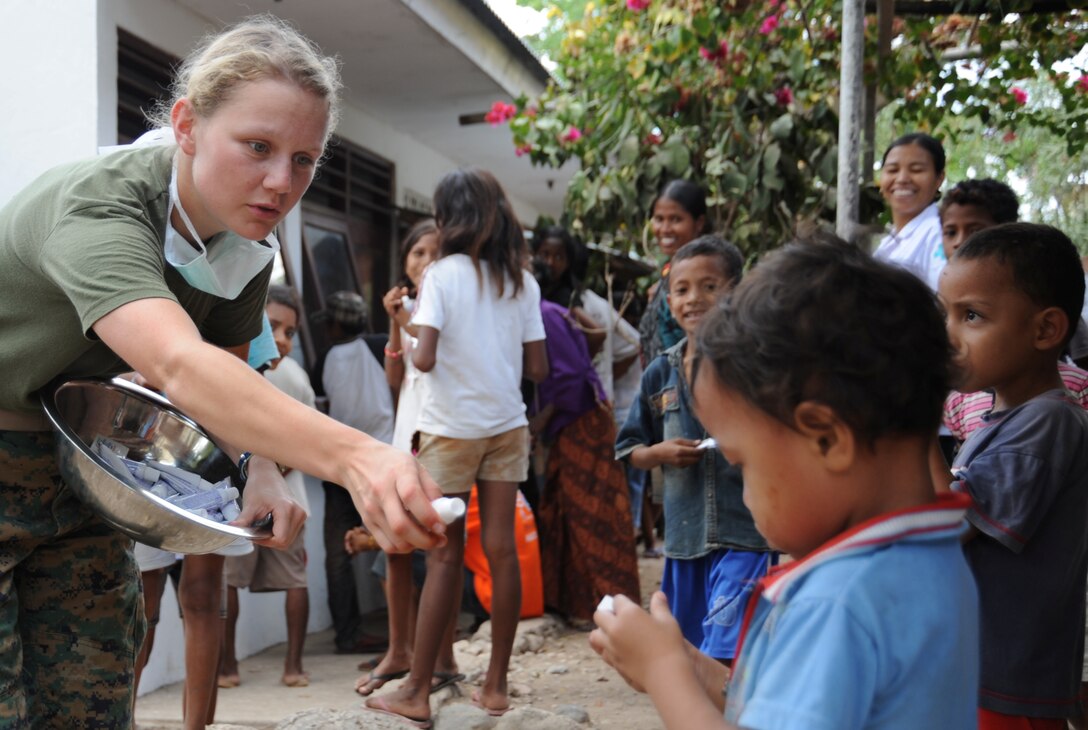 Petty Officer 2nd Class Rachel Arndt, 23, from Wauwatosa, Wis., hands out toothpaste at a clinic here Oct. 21. Arndt and other medical personnel from the 11th Marine Expeditionary Unit treated patients at two clinics and a hospital in Timor Leste Oct. 15-21.