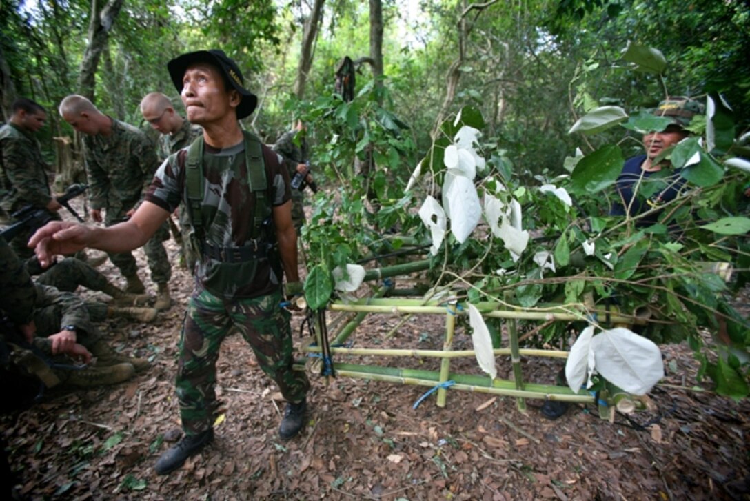 Indonesian Marines teach members of Battalion Landing Team 2/4, 11th Marine Expeditionary Unit, how to set booby traps during jungle survival training here Oct. 21. Members of the 11th MEU are in Indonesia for an exercise focused on medical and dental assistance, engineering projects and military interaction.