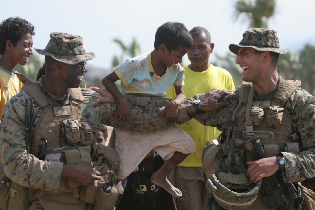 Second Lt. Jared Muse (left) and 1st Lt. Cicero Runningcrane, Marines with Company E, Battalion Landing Team 2/4, 11th Marine Expeditionary Unit, entertain kids from a nearby village here Oct. 22. The Marines were in Timor Leste doing jungle training with the Timor Leste Defense Force and Australian soldiers with the International Stabilization Force during an exercise there.