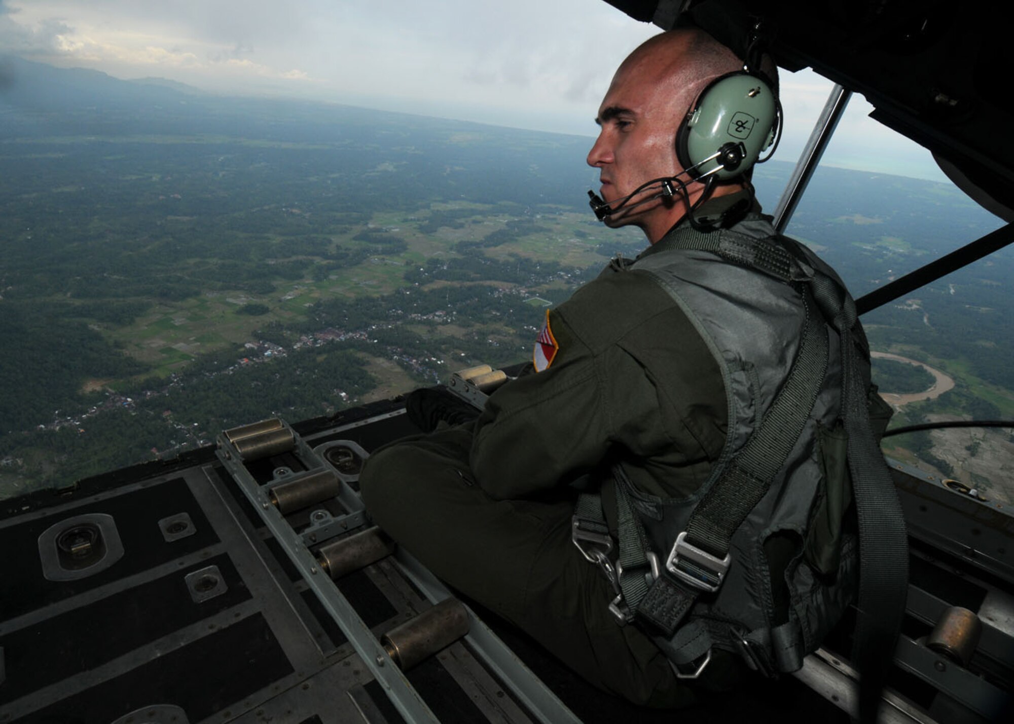 PADANG, Indonesia -- Tech. Sgt. Mike Militch a MC-130P Combat Shadow loadmaster from the 17th Special Operations Squadron  performs a visual scan for precautionary measures while in route to receive humanitarian aid supplies from Tabing Air Field Oct. 13. More than 65 members of the group provided their unique expertise in key areas to multiple organizations supporting relief efforts across the affected area. (U.S. Air Force photo by Staff Sgt. Veronica Pierce)