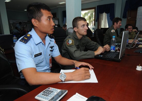 JAKARTA, Indonesia -- Capt. Chuck Dokmo from the 17th Special Operations Squadron, works with his Indonesian Air Force counterpart tracking air operations relief efforts in the Combined Air Mobility Division Oct. 13. The 353rd Special Operations Group, Royal Australian Air Force and Indonesian Air Force developed the CAMD at Halim Air Base, Jakarta to amicably supply aid to those affected. More than 65 members of the group provided their unique expertise in key areas to multiple organizations supporting relief efforts across the affected area. (U.S. Air Force photo by Staff Sgt. Veronica Pierce)