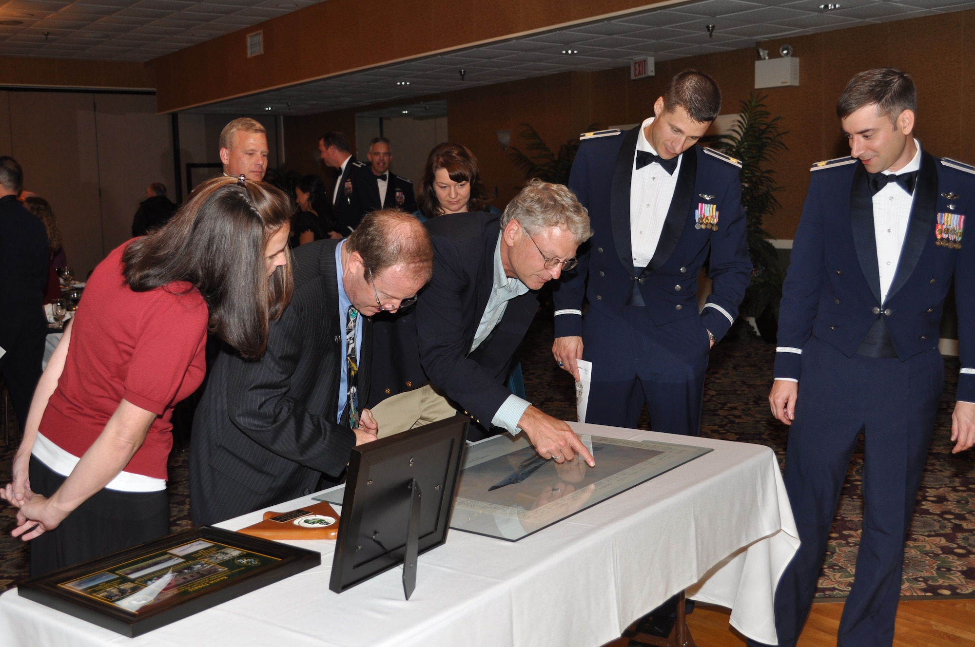 Mr. Keith Ferris, Air Force aviation artist, presents a gift to the 49th Fighter Training Squadron.  The gift is an artist print by Mr. Ferris that is signed by the members of the 49th Fighter Interceptor Squadron and was originally presented to him in 1986. (U.S. Air Force photo/Sonic Johnson).