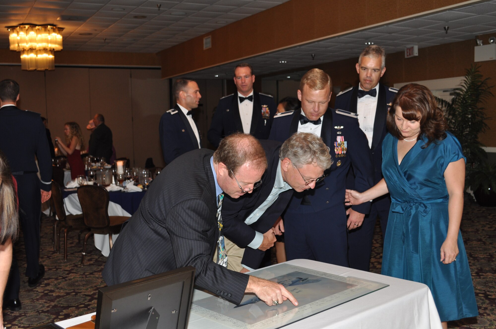 Mr. Keith Ferris, Air Force aviation artist, presents a gift to the 49th Fighter Training Squadron.  The gift is an artist print by Mr. Ferris that is signed by the members of the 49th Fighter Interceptor Squadron and was originally presented to him in 1986. (U.S. Air Force photo/Sonic Johnson).