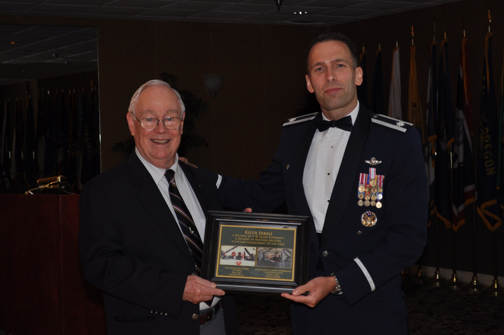 Lt. Col. Tor Dietrichs, 49th Fighter Training Squadron Commander, presents a gift to Mr. Keith Ferris, Air Force aviation artist, thanking him for his speech at the 49th Fighter Squadron Association banquet. (U.S. Air Force photo/Sonic Johnson).
