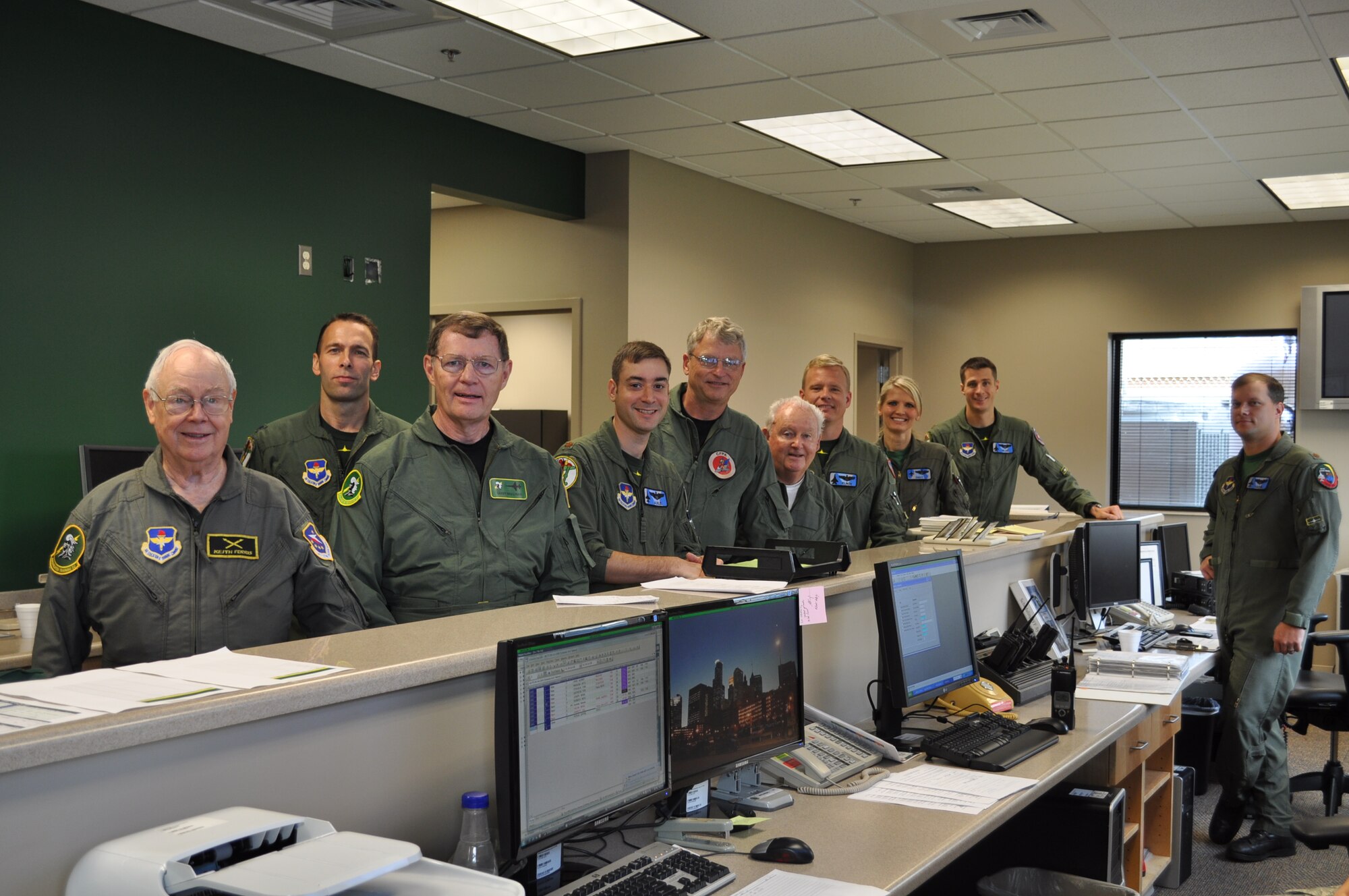 Orientation flyers of the 49th Fighter Squadron Associaton and their instructor pilots stand by the 49th Operations Desk prior to flight. (U.S. Air Force photo/Sonic Johnson).