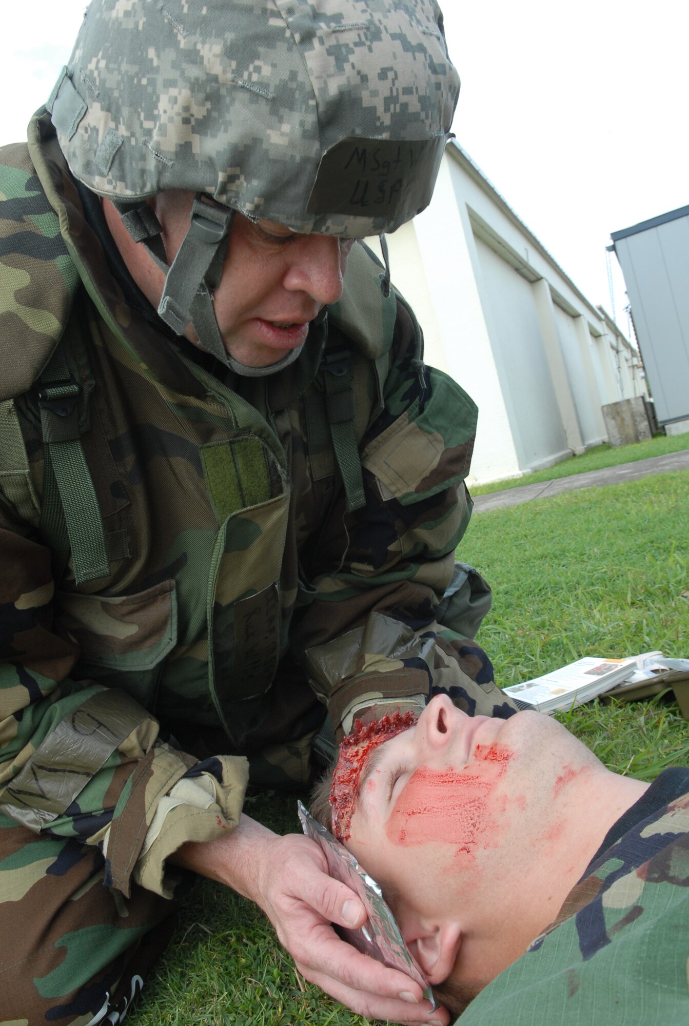 Master Sgt. Ricky Willis from the 18th Communications Squadron gives first aid to Staff Sgt. Christopher Hummel, 18th Wing Public Affairs, as part of a training scenario during the local operational readiness exercise at Kadena Air Base Oct. 22. (U.S. Air Force photo / Junko Kinjo)