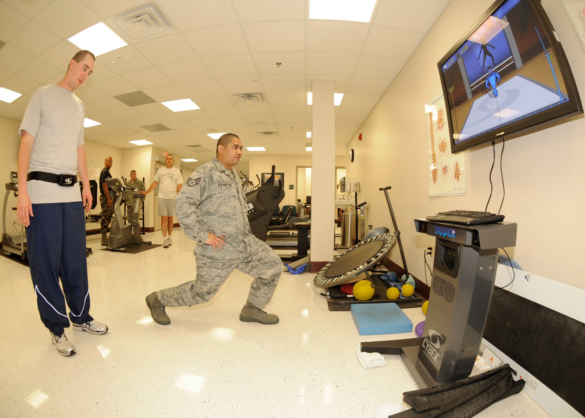 Staff Sgt. Jun Espartero, right, 22nd Medical Operations Squadron, shows Senior Airman Joseph Milledge, 22nd Logistics Readiness Squadron, stretching techniques, Oct. 20, 2009, while using an interactive video technology system at the McConnell Air Force Base, Kan., Physical Therapy Clinic. The “virtual gym” improves a patient’s stability, strength, agility, flexibility, cardiovascular and aerobic endurance and can be set to different levels of intensity. (U.S. Air Force photo/Staff Sgt. Jamie Train)