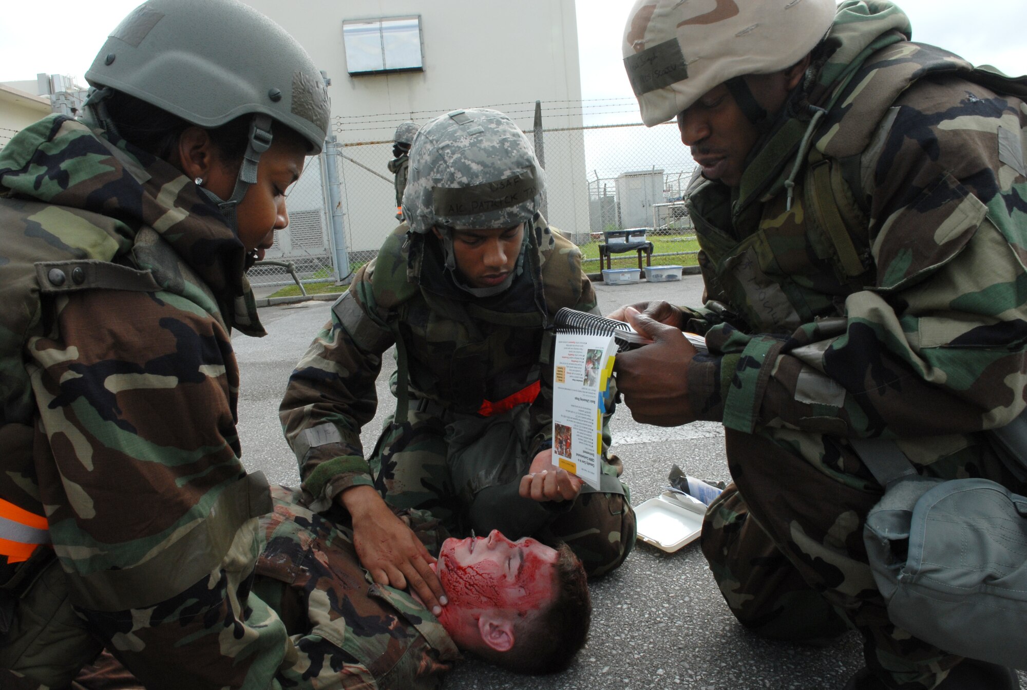 Master Sgt. Felisha Haman, Airman 1st Class Patrick Taylor and Tech. Sgt Marcus Joseph, all members of the 18th Communications Squadron, provide first aid care to Airman 1st Class Nickolaus Miller from the 33rd Aircraft Maintenance Unit in a training scenario during the local operational readiness exercise at Kadena Air Base Oct. 22. (U.S. Air Force photo / Junko Kinjo)