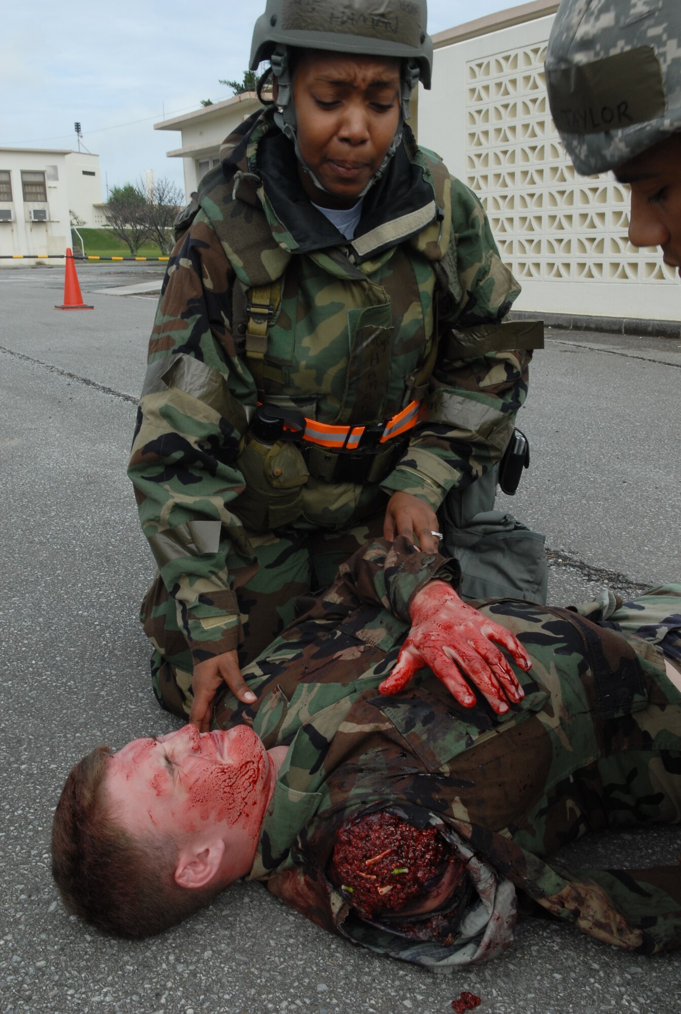 Master Sgt. Felisha Haman, 18th Communication Squadron first sergeant, provides first aid care to Airman 1st Class Nickolaus Miller from the 33rd Aircraft Maintenance Unit in a simulation during the local operational readiness exercise at Kadena Air Base Oct. 22. (U.S. Air Force photo / Junko Kinjo)