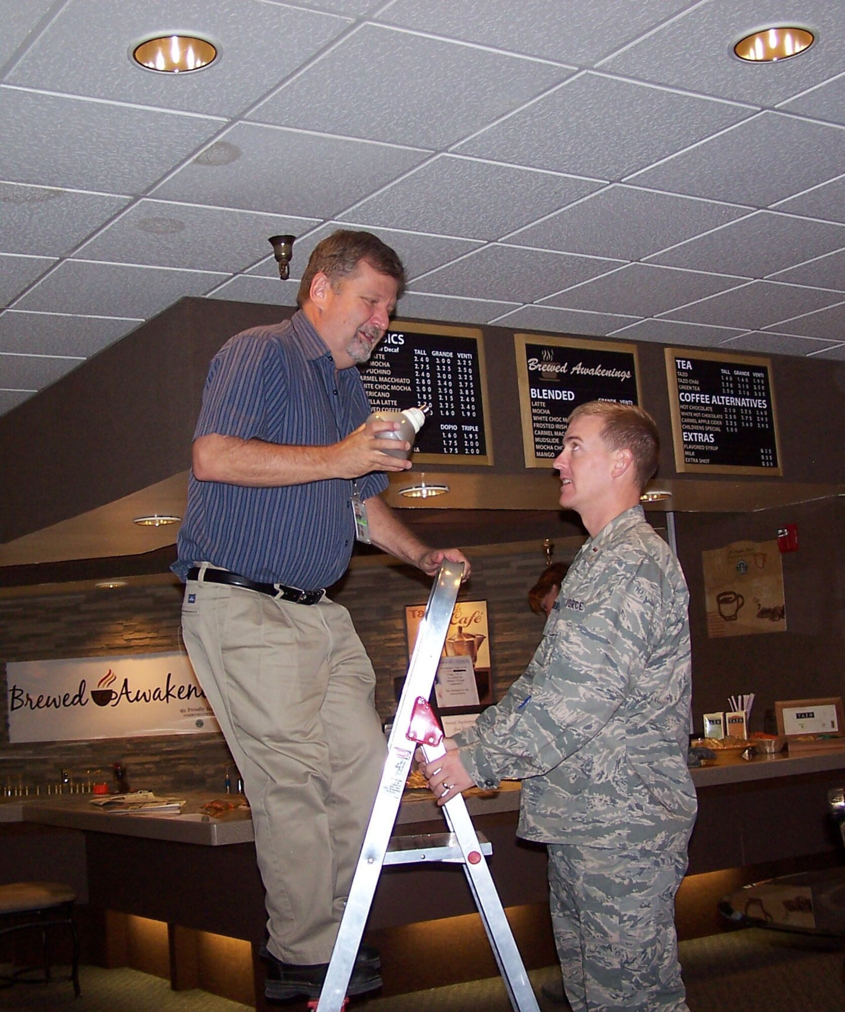 HOLLOMAN AIR FORCE BASE, N.M. -- 2nd Lt. Kevin Diefenderfer, 49th Civil Engineer Squadron energy manager and Gary Krivokaich, 49 CES resource efficiency manager, changed out incandescent lamps with compact fluorescent lamps at the Raptor's Nest here. During their lifetime, the CFL lamps at the Raptor's Nest will each save up to $36 in energy costs. The total change out to CFLs at the Raptor's Nest will save more than $2,000 a year. (Photo provided by Gary Krivokaich)