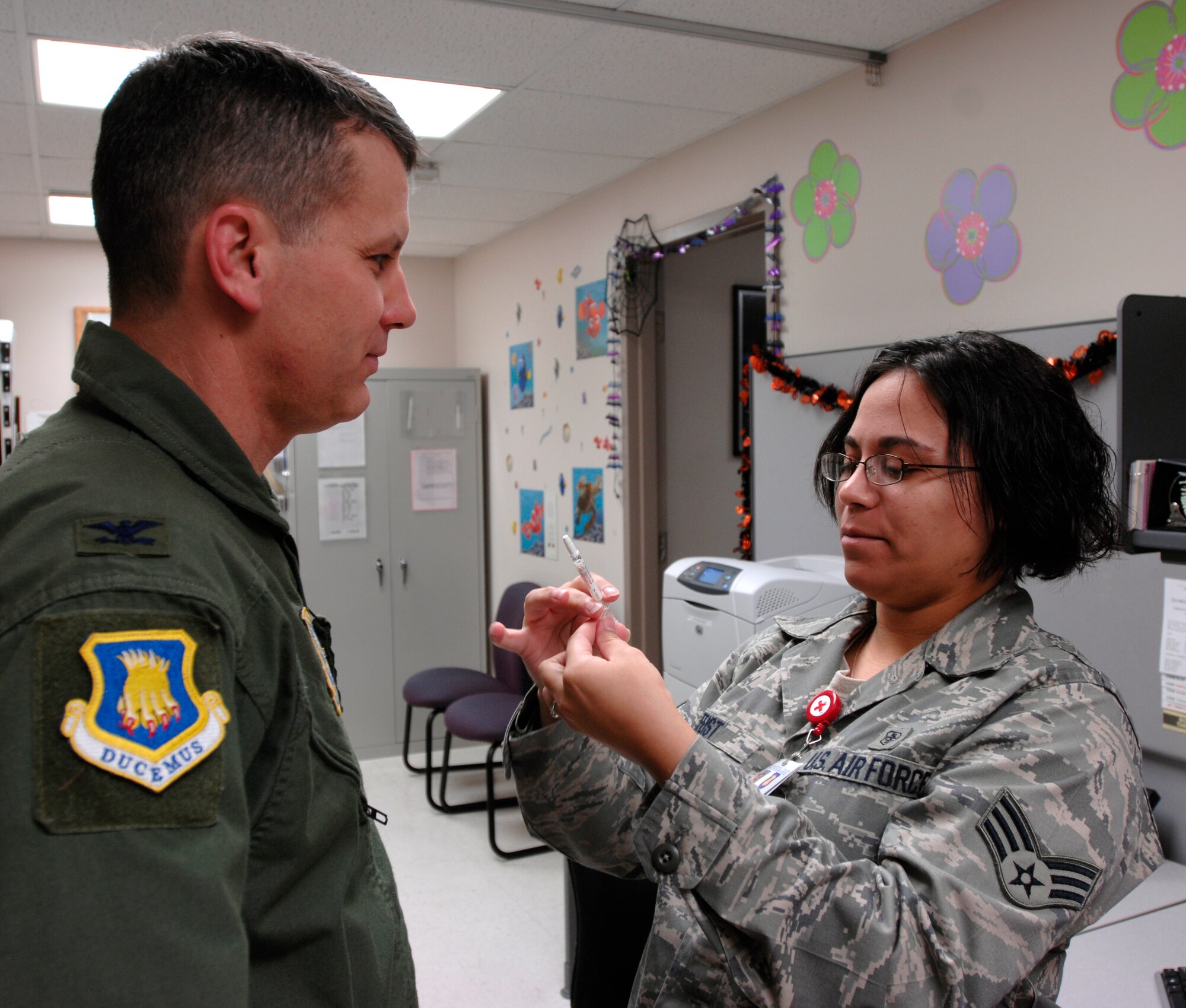 Senior Airman Valeria Feist, 22nd Medical Operations Squadron immunization technician, prepares a seasonal flu mist vaccine for Col. James Crowhurst, 22nd Air Refueling Wing commander, Oct. 21, 2009, at the McConnell Immunization Clinic. Flu vaccines are mandatory for servicemembers. McConnell is expecting H1N1 vaccines by mid- to late November. (U.S. Air Force photo/Senior Airman Laura Suttles)