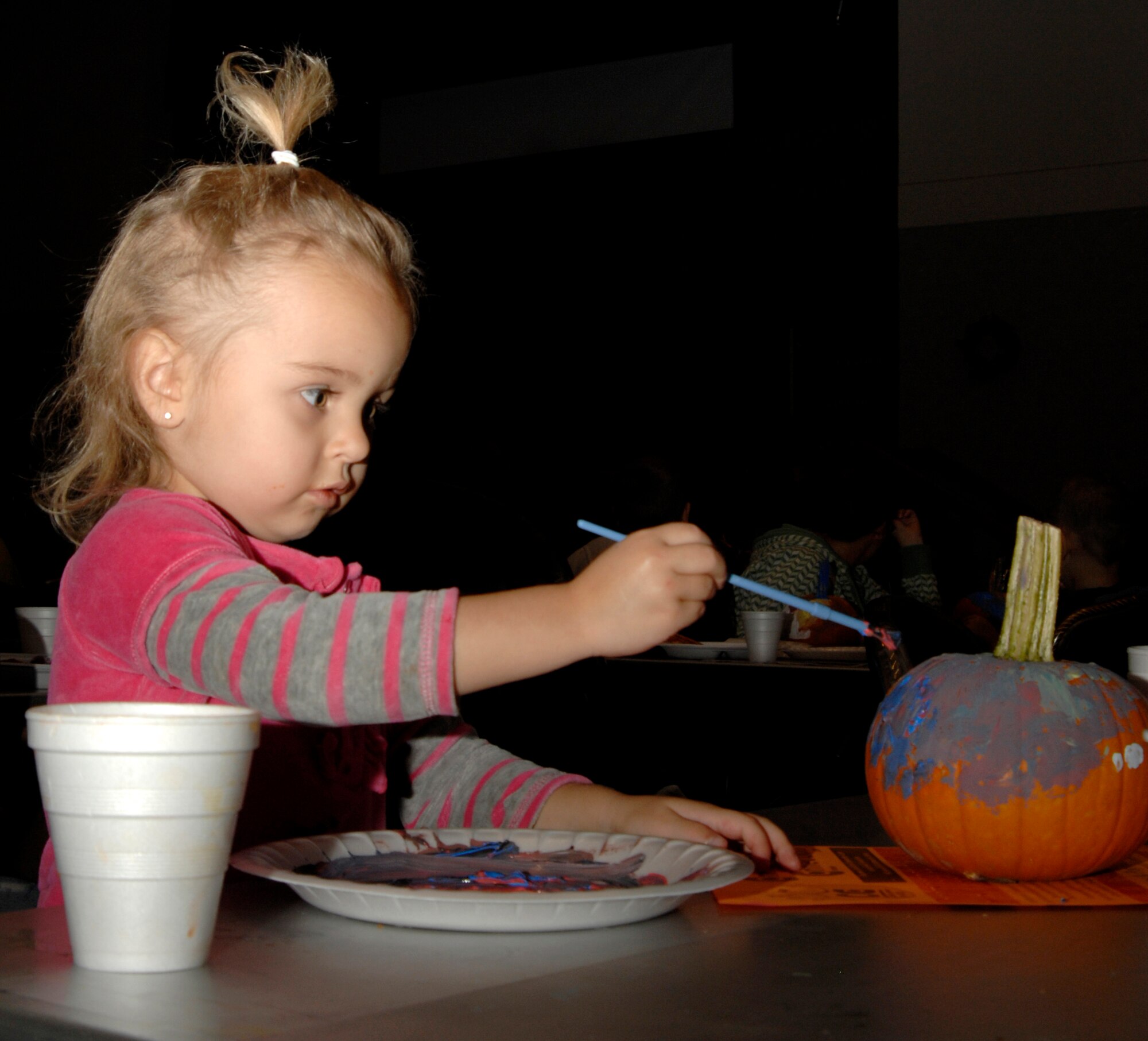 Team McConnell member Josephine Lee, 3, paints a pumpkin during a family night event, Oct. 9, 2009, at McConnell Air Force Base, Kan. The 22nd Force Support Squadron Services Flight event provided 100 pumpkins for children to decorate as well as offered food, drinks and games to McConnell families. (U.S. Air Force photo/Senior Airman Laura Suttles)