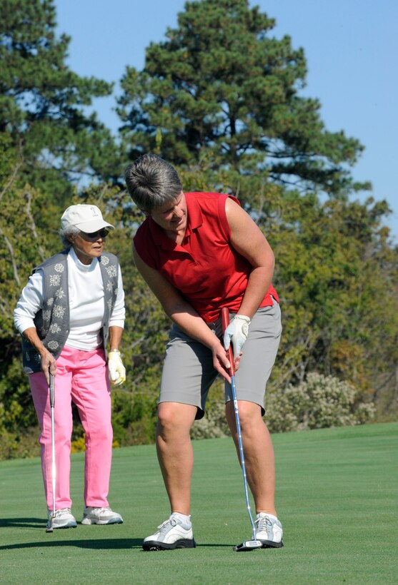 LANGLEY AIR FORCE BASE, Va. - WO1 Fiona Stapley, British Army Ladies Golf Team member, putts on the green while Ping Ying, Eaglewood Women's Golf Association member, looks on here Oct. 21. The team tours biennially; this year the team competed at three Virginia military installations. (U.S. Air Force photo/ Senior Airman Dana Hill)