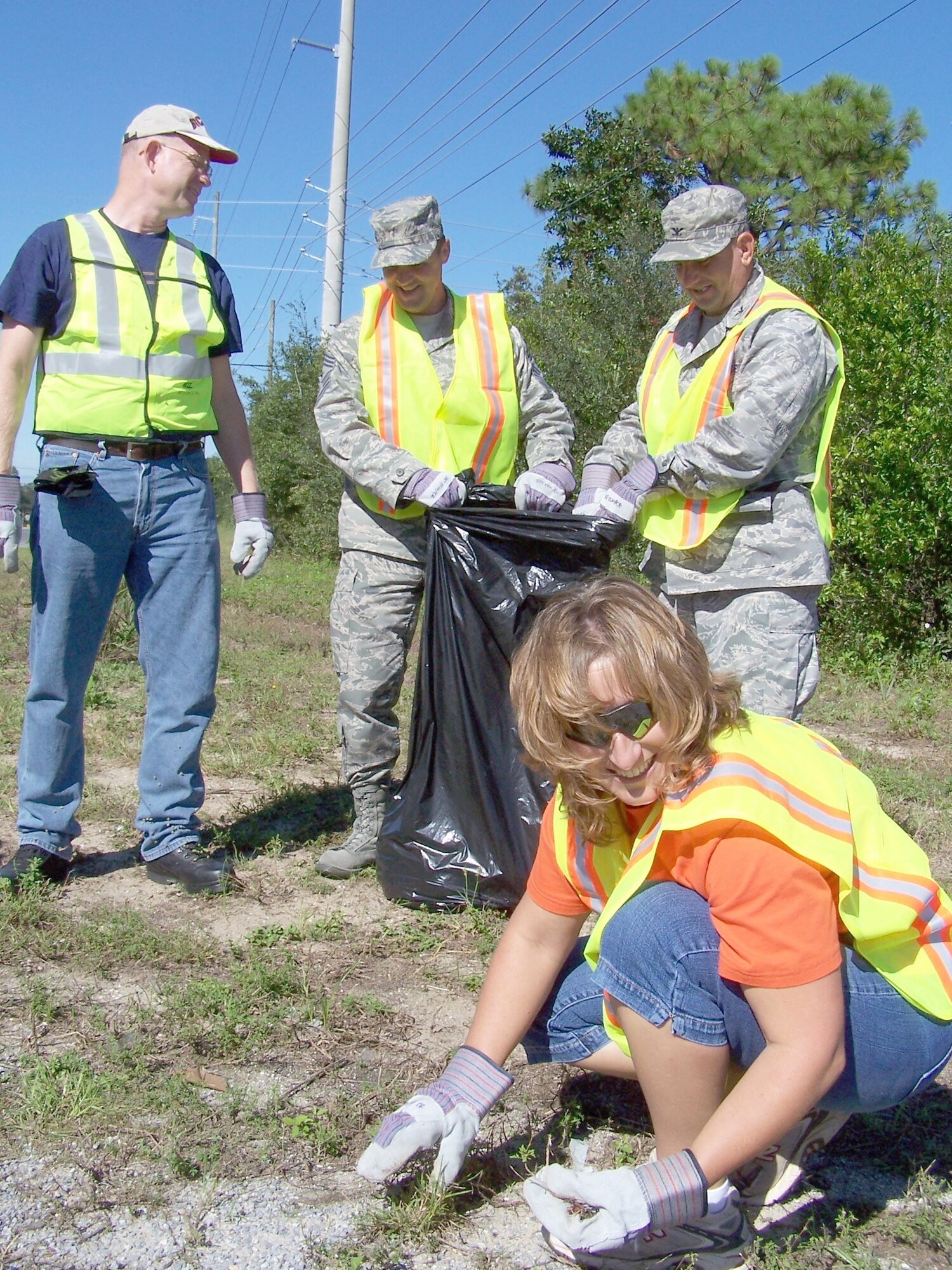 FORT WALTON BEACH, Fla. - The 505th Command and Control Wing picked up refuse along James Lee Road on Oct. 16, in keeping with the Adopt-A-County Road program. The Wing adopted the road and comes out every few months to keep it clean. From left are Lt. Col. Bob Bower, Chief Master Sgt. Deno Mackin, command chief, 505 CCW Commander Col. Edward McKinzie, and Valerie Mackin, wife of Chief Mackin. (U.S. Air Force photo by Noel Getlin) 
