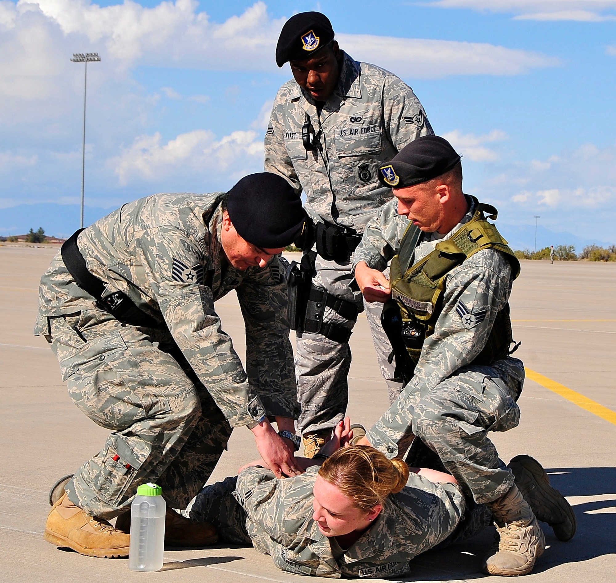 HOLLOMAN AIR FORCE BASE, N.M. -- Tech. Sgt. Christopher Ahumada and Senior Airman Wayne Grubbs, 49th Security Forces Squadron, apprehend Airman 1st Class Sarah Garrett, 49th Operations Support Squadron, while Airman 1st Class Raneisha Wyatt, 49th SFS, assists during a Major Accident Respone Exercise here Oct. 20. Airman Garrett was a role player in the MARE and the 49th Security Forces Squadron is keeping her from reentering the simulated accident scene. The MARE was designed to prepare Team Holloman for any event that could occur during the upcoming Open House. (U.S. Air Force photo by Tech. Sgt. Chris Flahive)