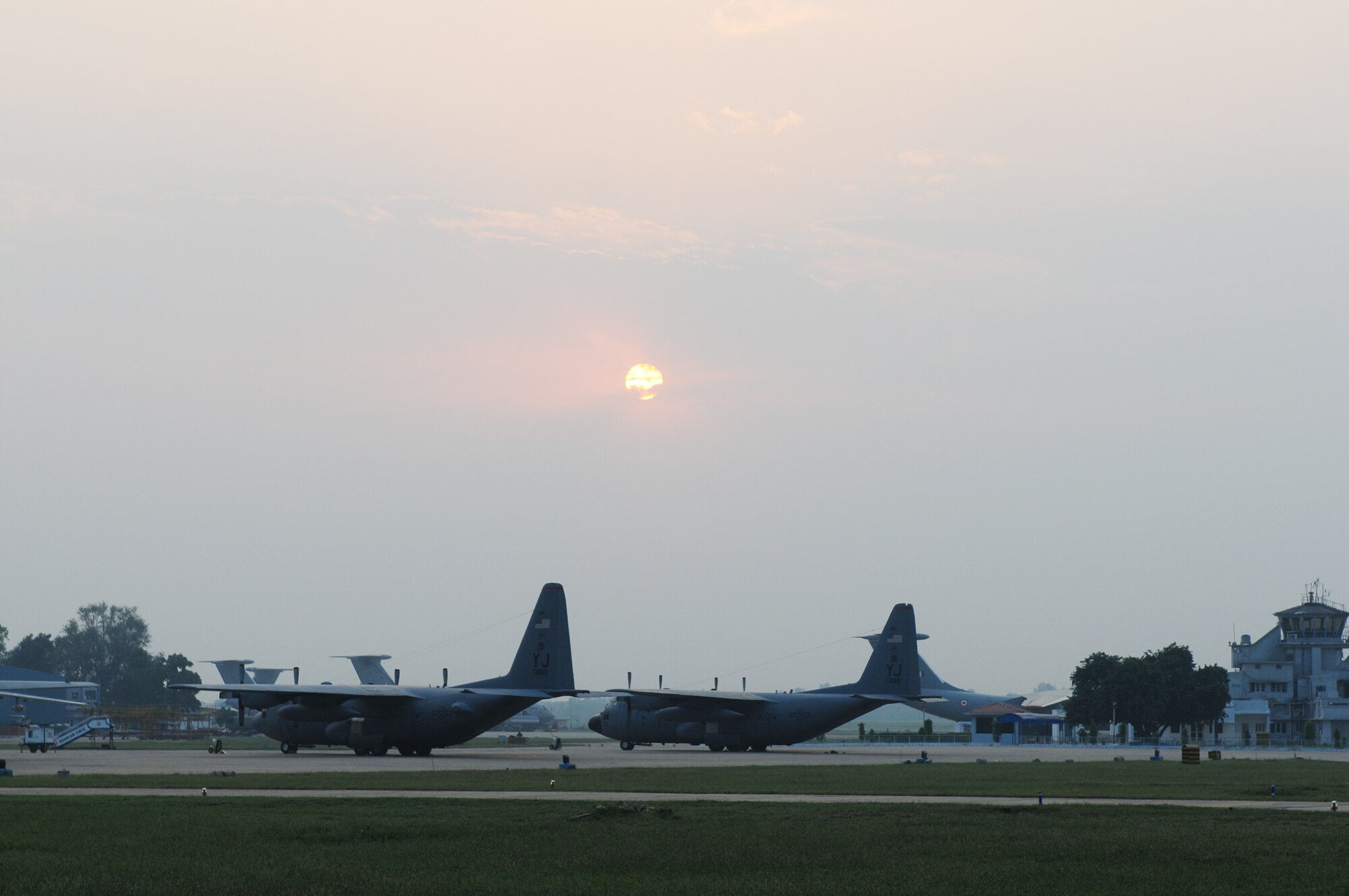 two U.S. Air Force C-130 Hercules aircraft from the 36th Airlift Squadron at Yokota Air Base, Japan, parked under a Indian sunset at Air Force Station Agra, India. The aircraft along with a C-17 Globemaster III and more than 150 U.S. Air Force and Army personnel are deployed here as part of exercise Cope India, a humanitarian assistance disaster relief exercise Oct. 19 to 24. (U.S. Air Force photo/Capt. Genieve David)