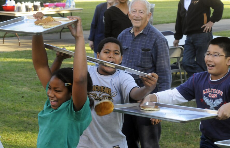Children used trays to catch some of the flying pancakes. U. S. Air Force photo by Sue Sapp